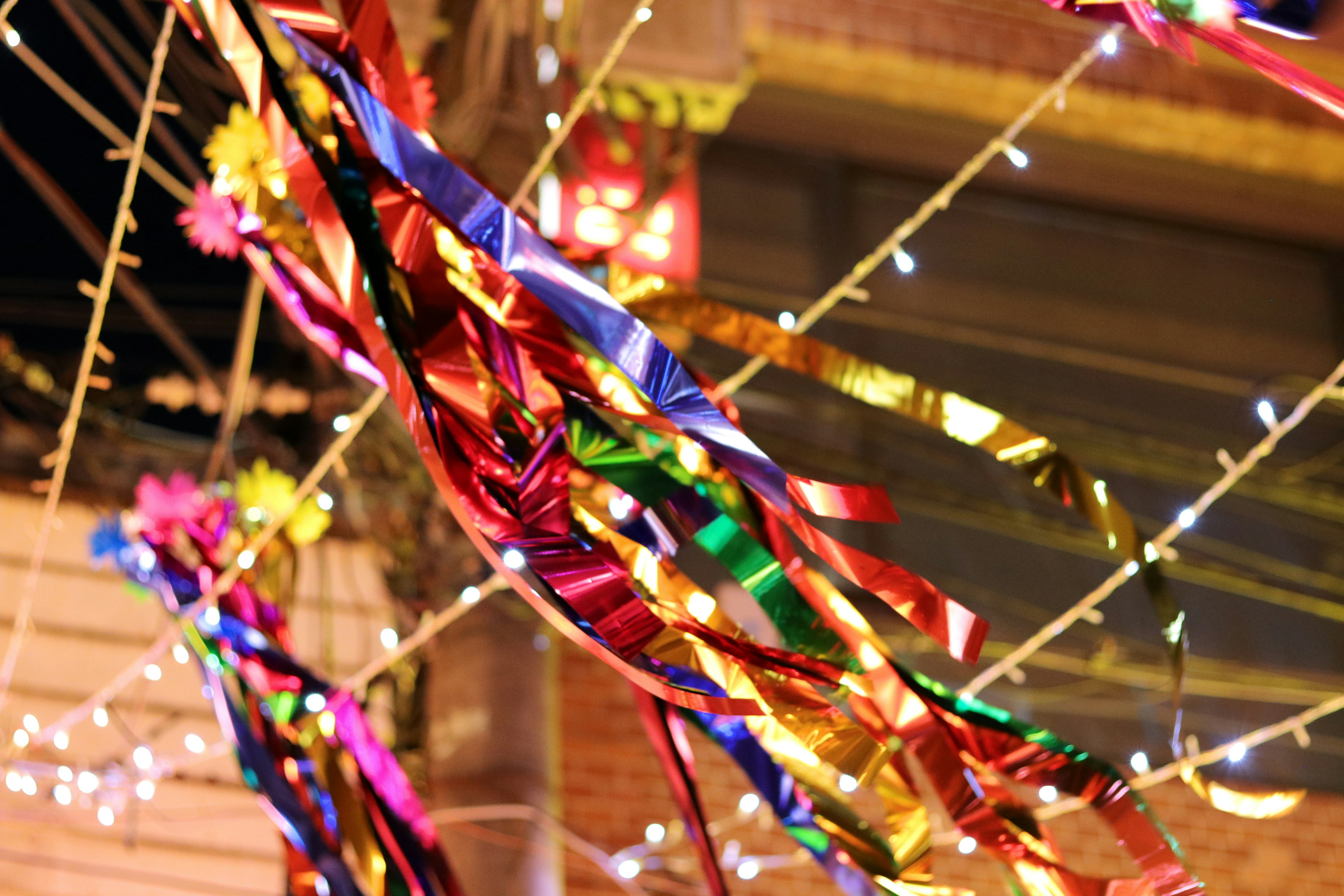 Cintas coloridas y luces brillantes adornando una escena al aire libre