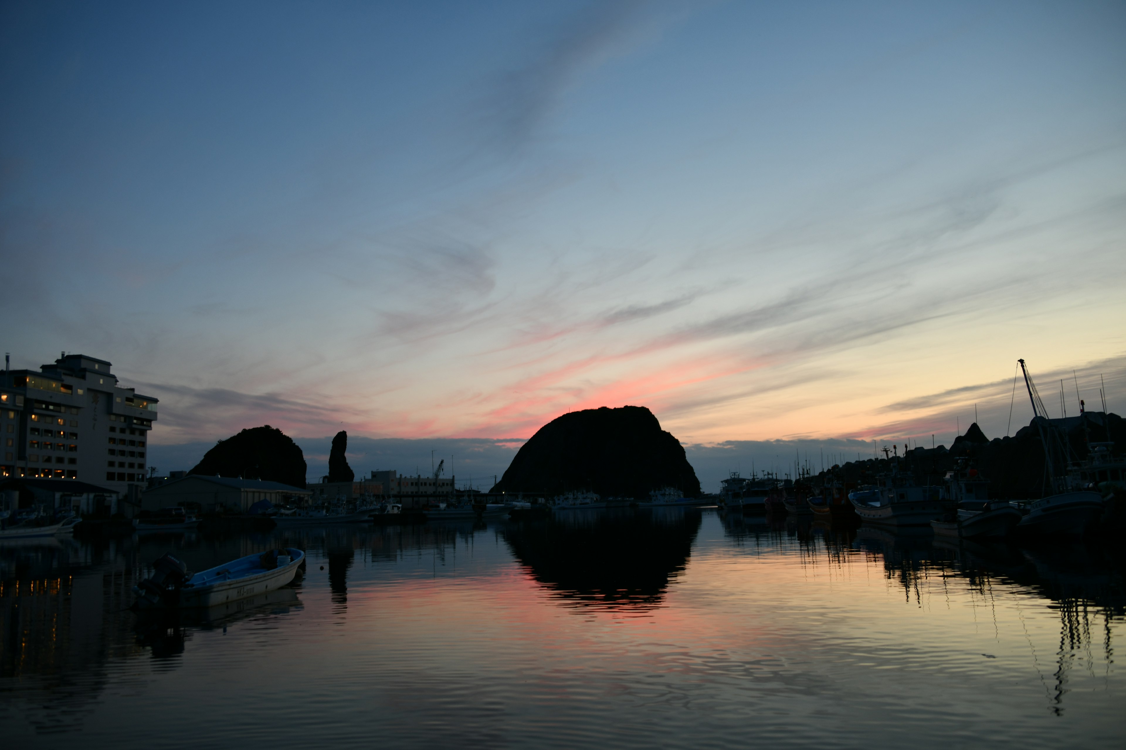 Silueta de colinas reflejada en el agua al atardecer