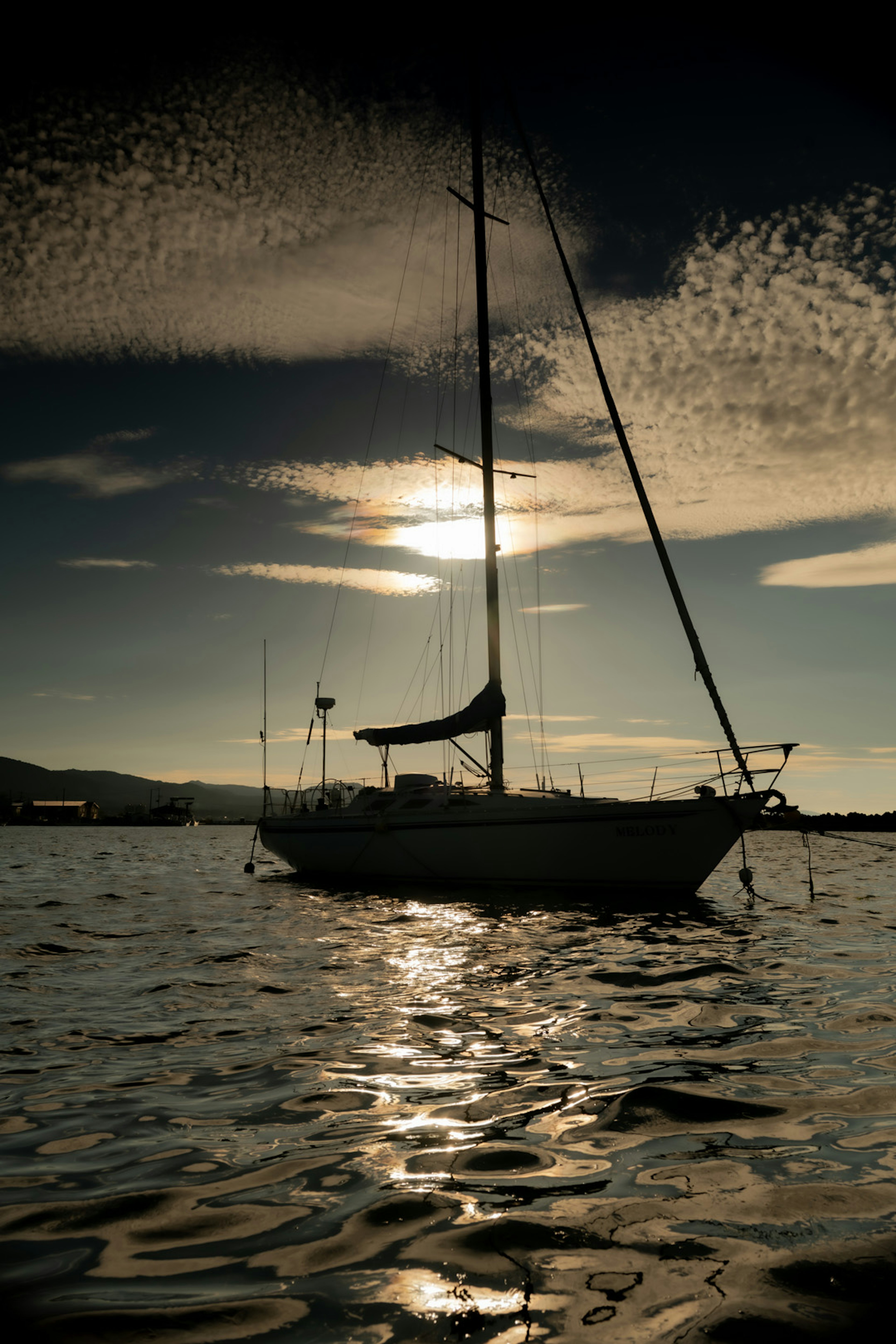 Velero flotando en agua tranquila con atardecer