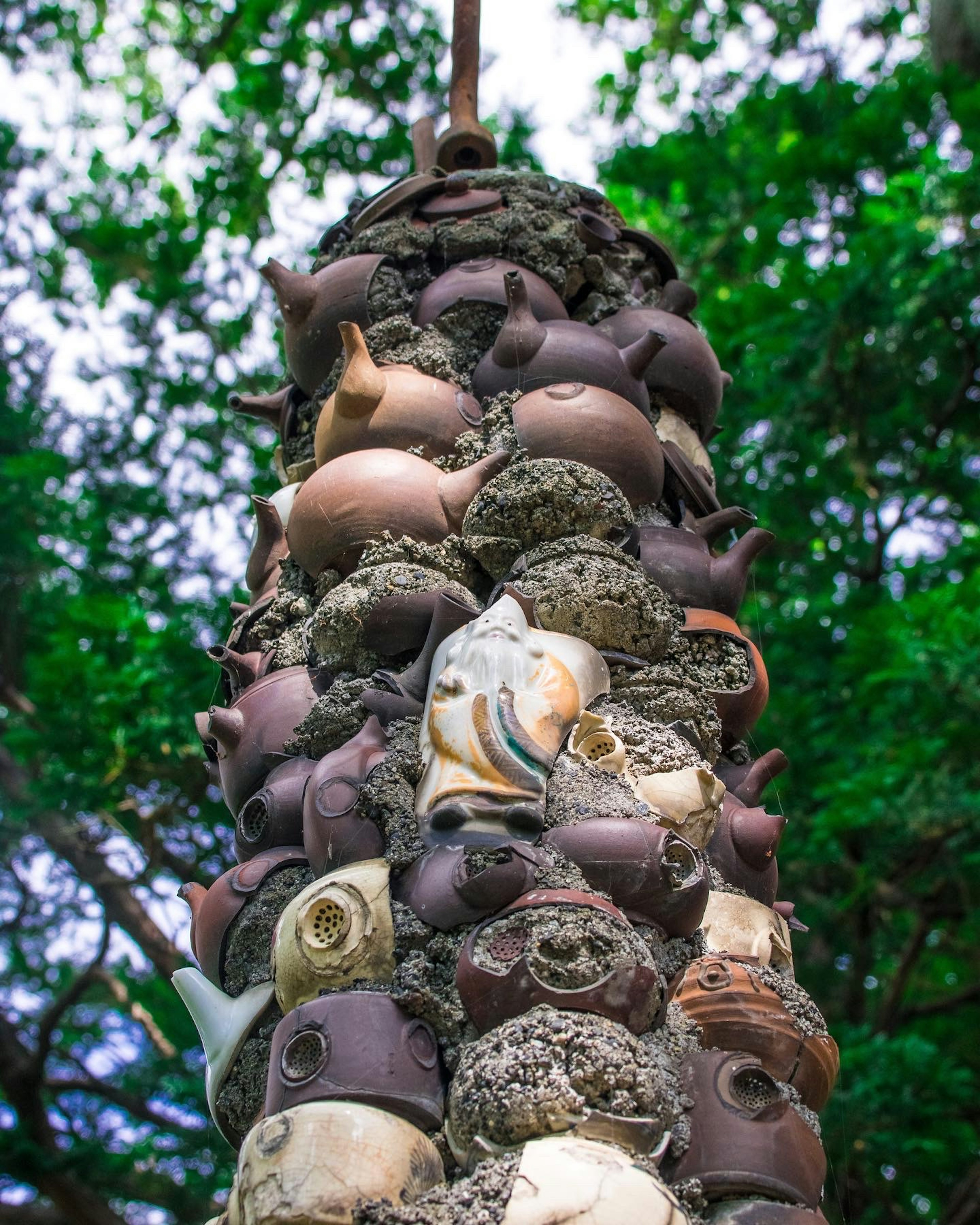 陶器の彫刻が積み重なった塔 緑の背景