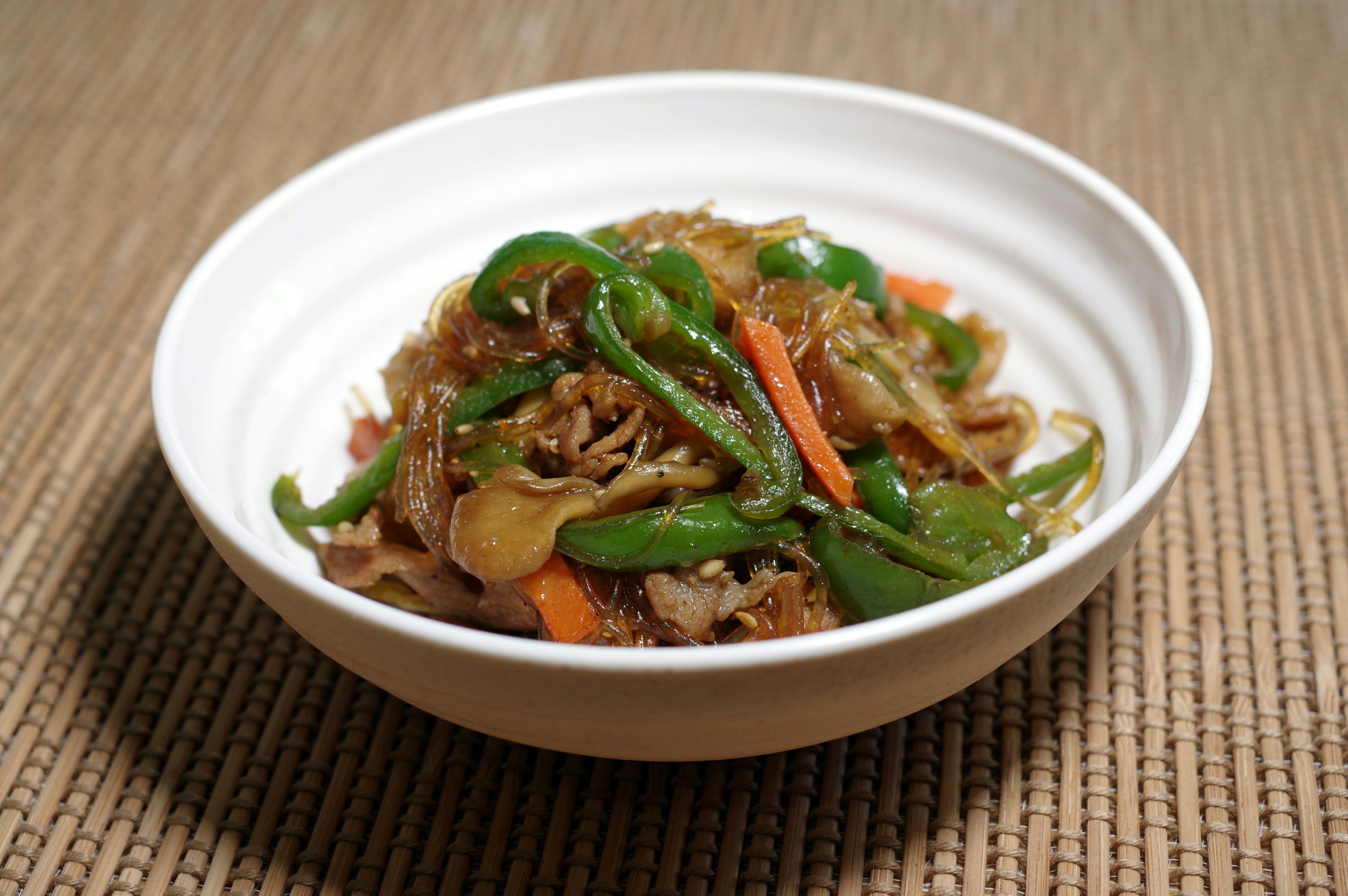 Stir-fried vegetables and meat served in a white bowl