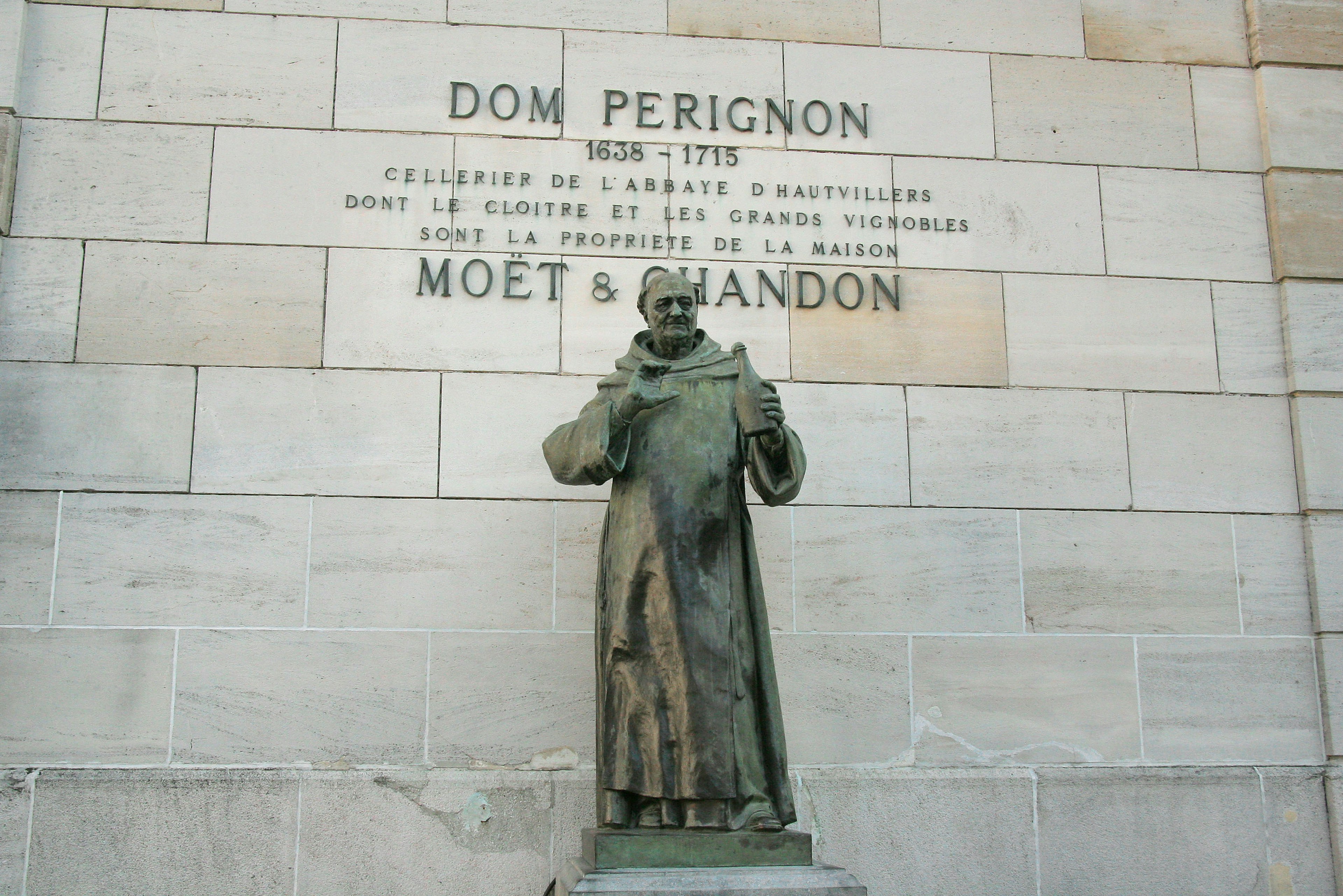 Estatua de Dom Perignon con inscripción de Moet & Chandon