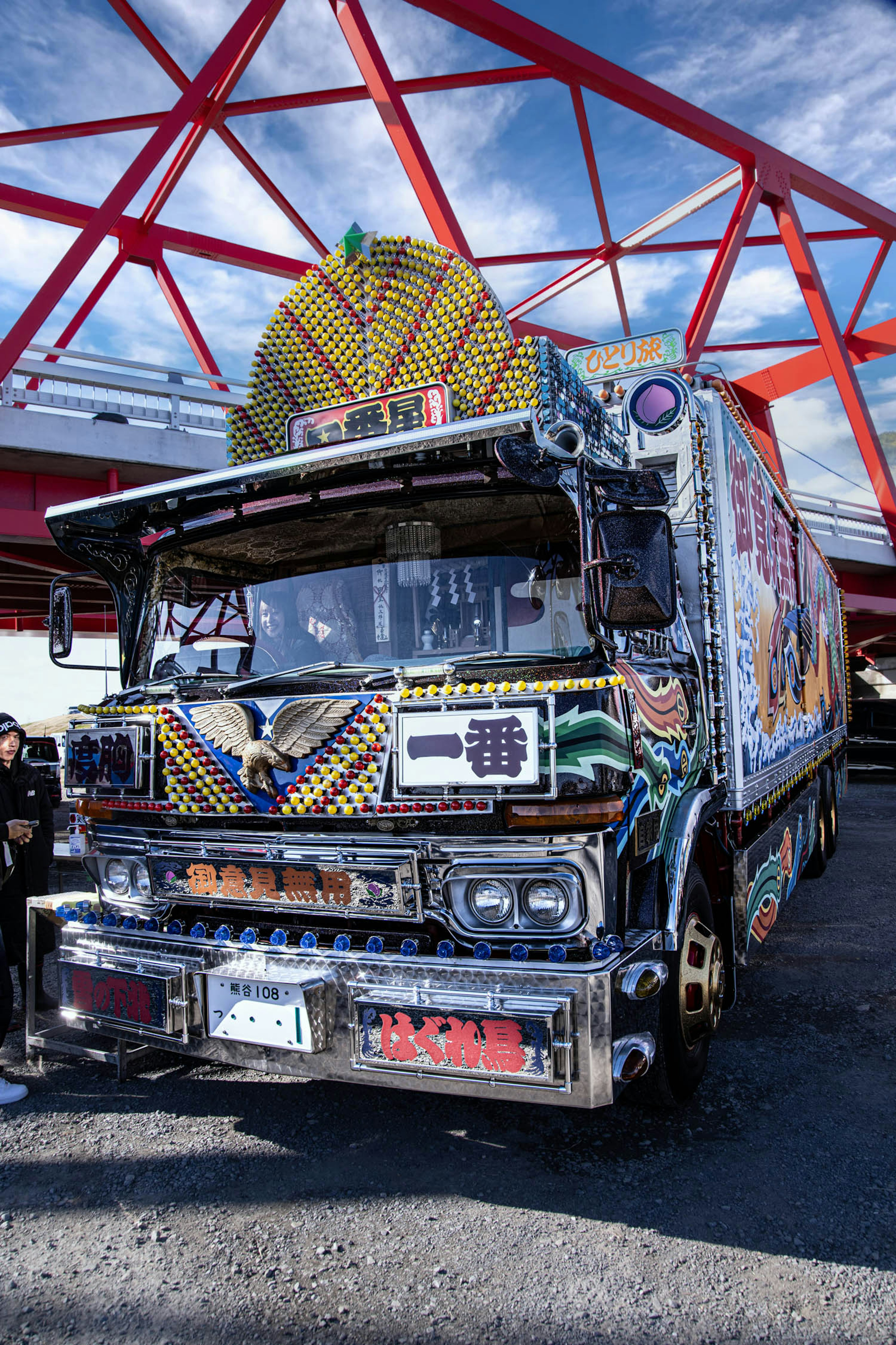 Truk yang dihias cerah terparkir di bawah jembatan merah