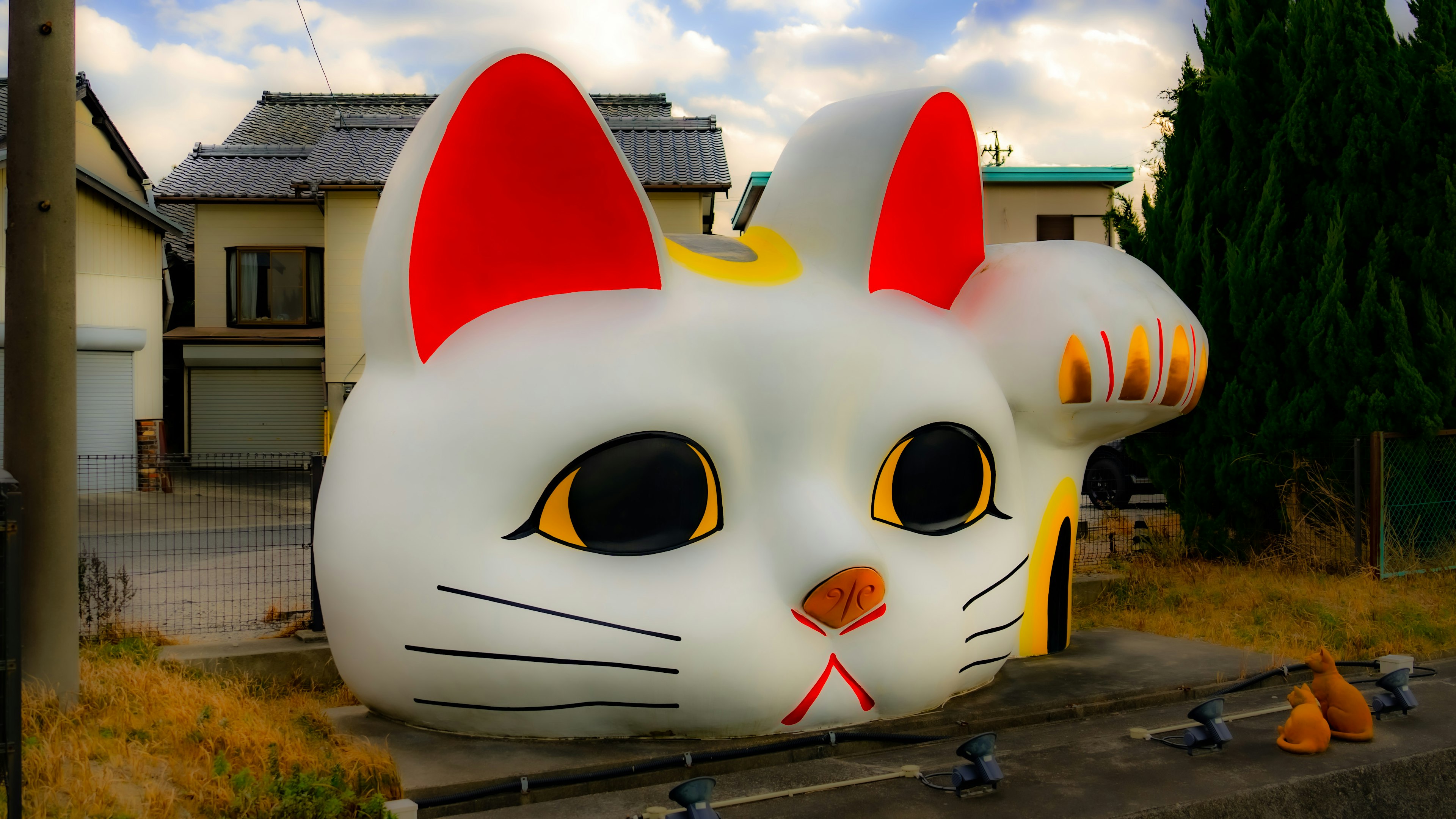 Edificio en forma de cara de gato gigante con orejas rojas y grandes ojos negros