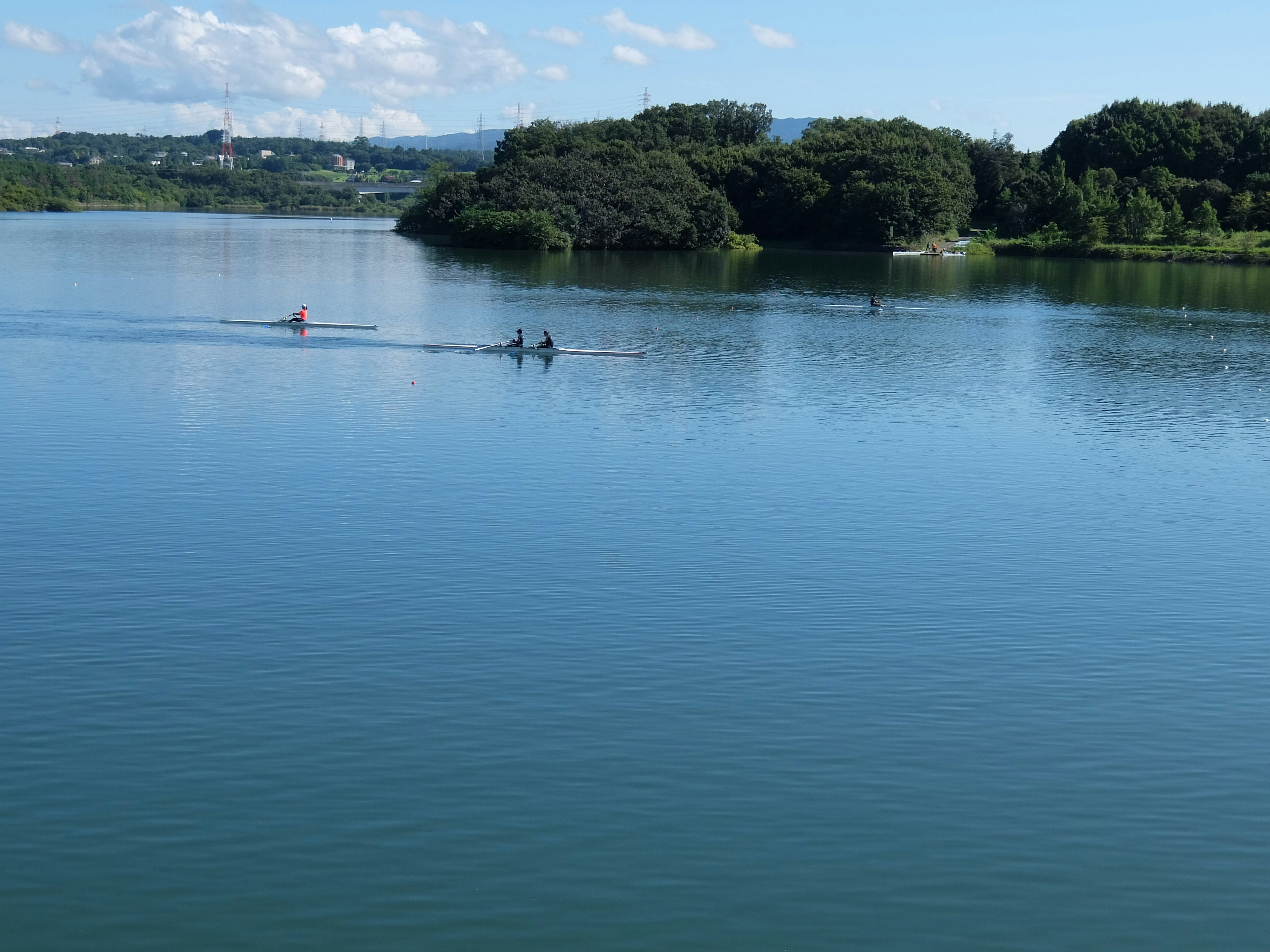 Personas haciendo kayak en un lago azul con islas verdes al fondo