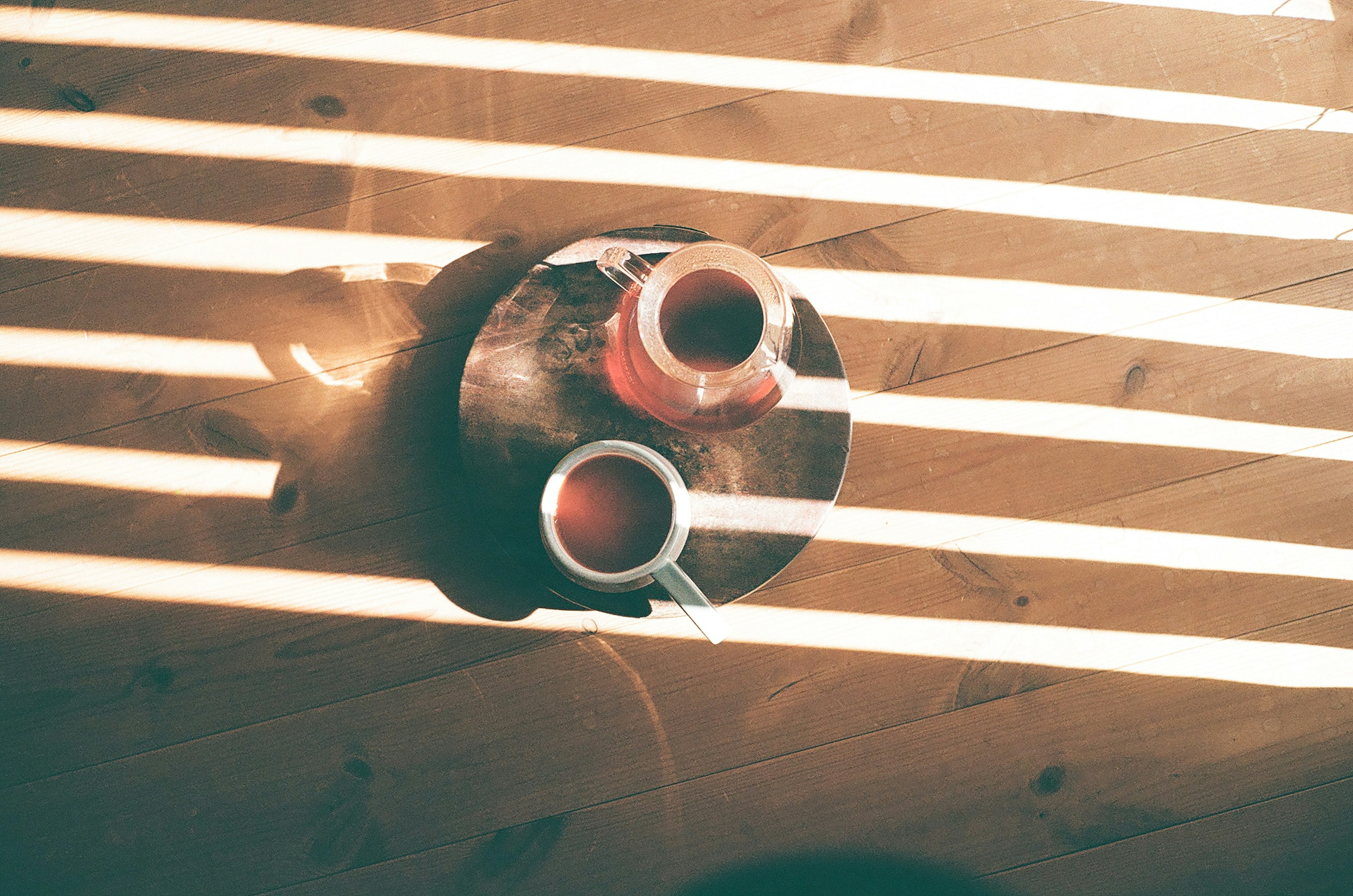 Two cups on a table with striped light