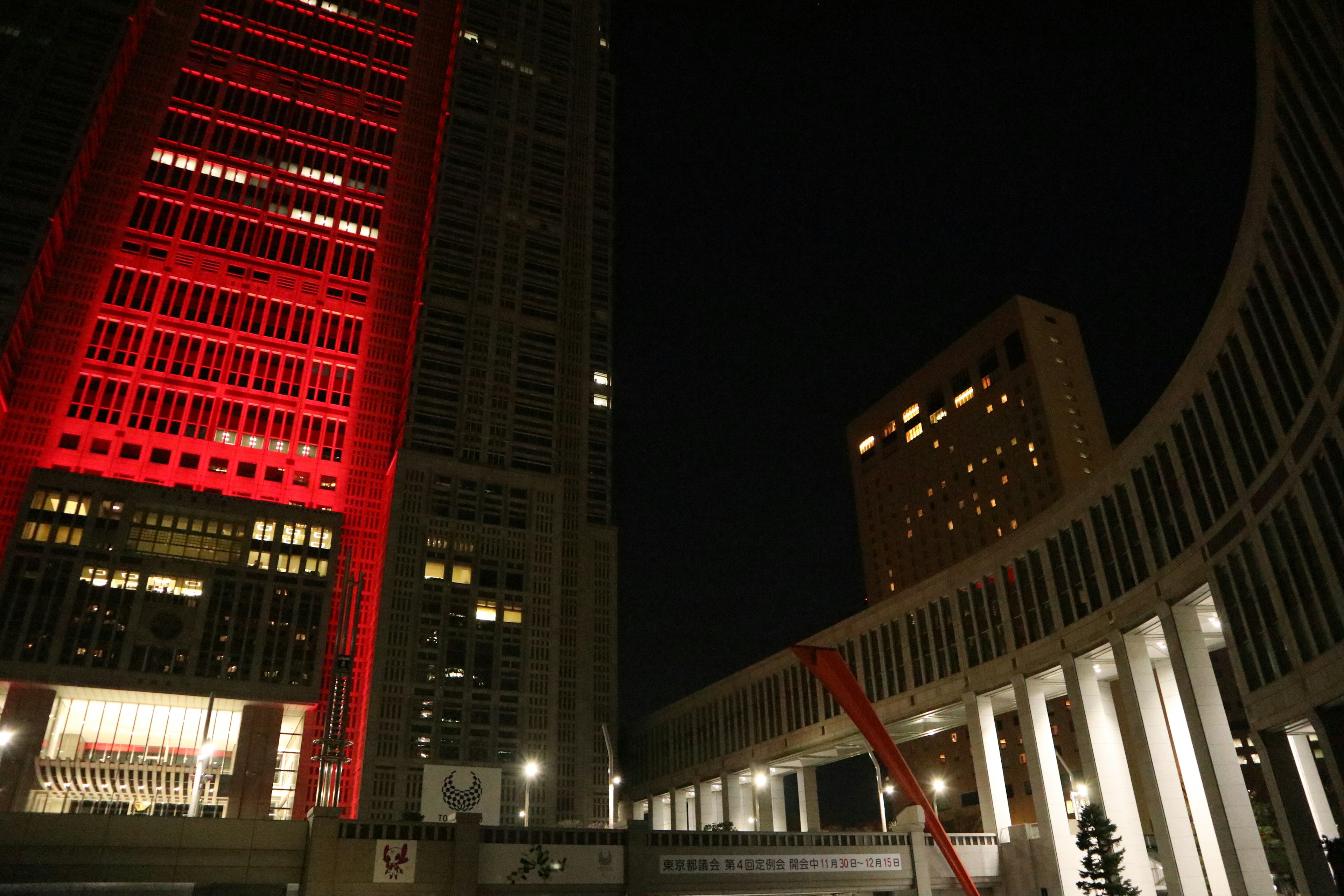 Vista nocturna de los rascacielos de Tokio con un edificio iluminado en rojo