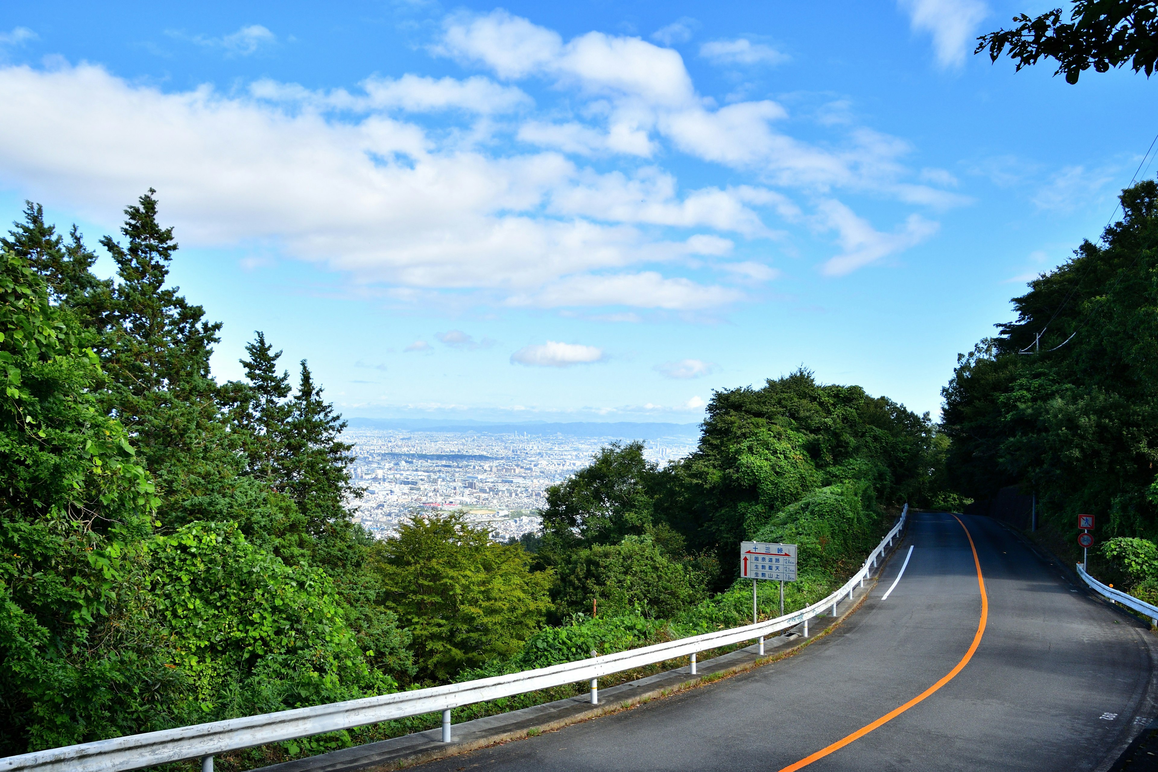 Winding road with lush greenery and open sky in the background