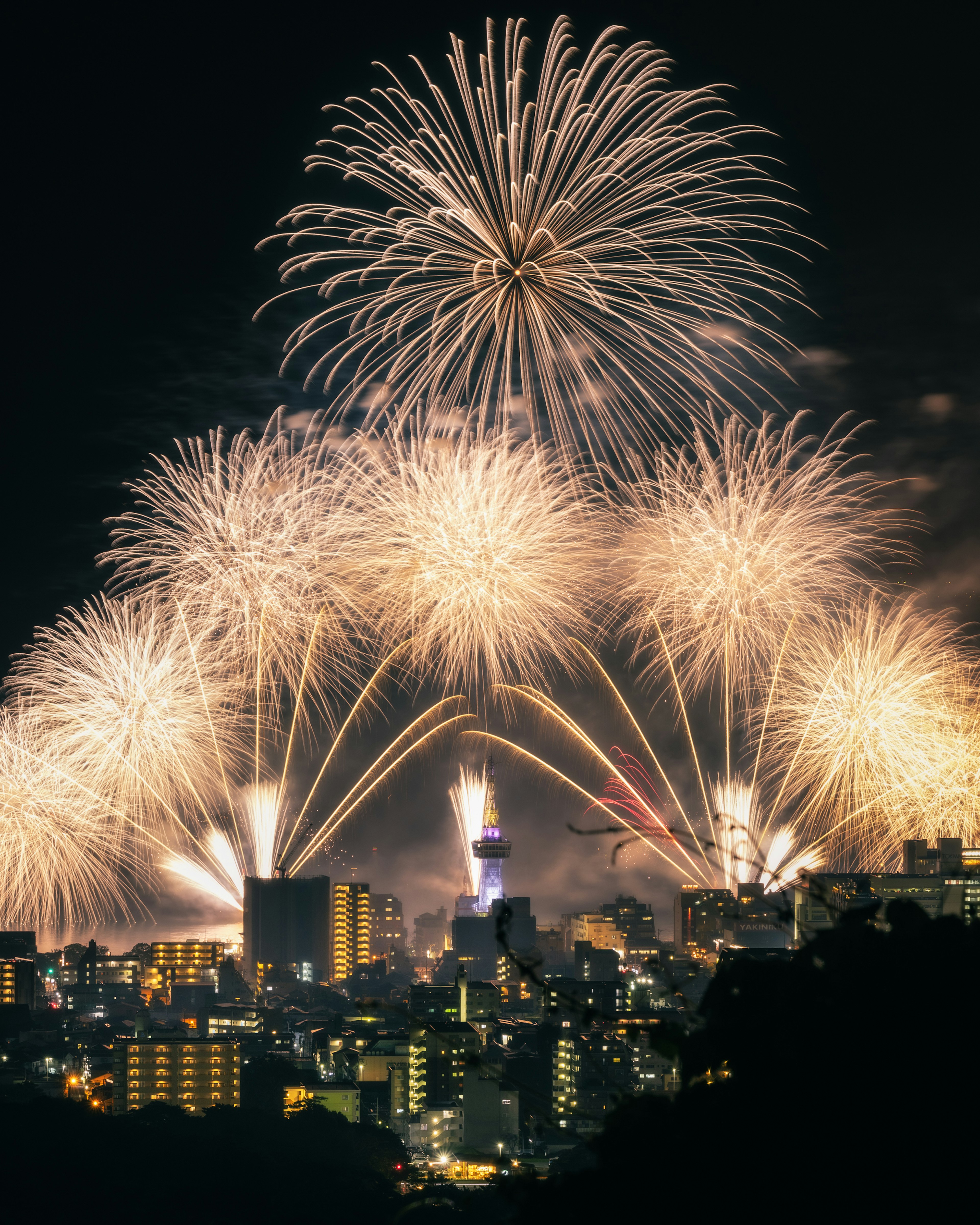 Feuerwerk erhellt den Nachthimmel über einer Stadtsilhouette