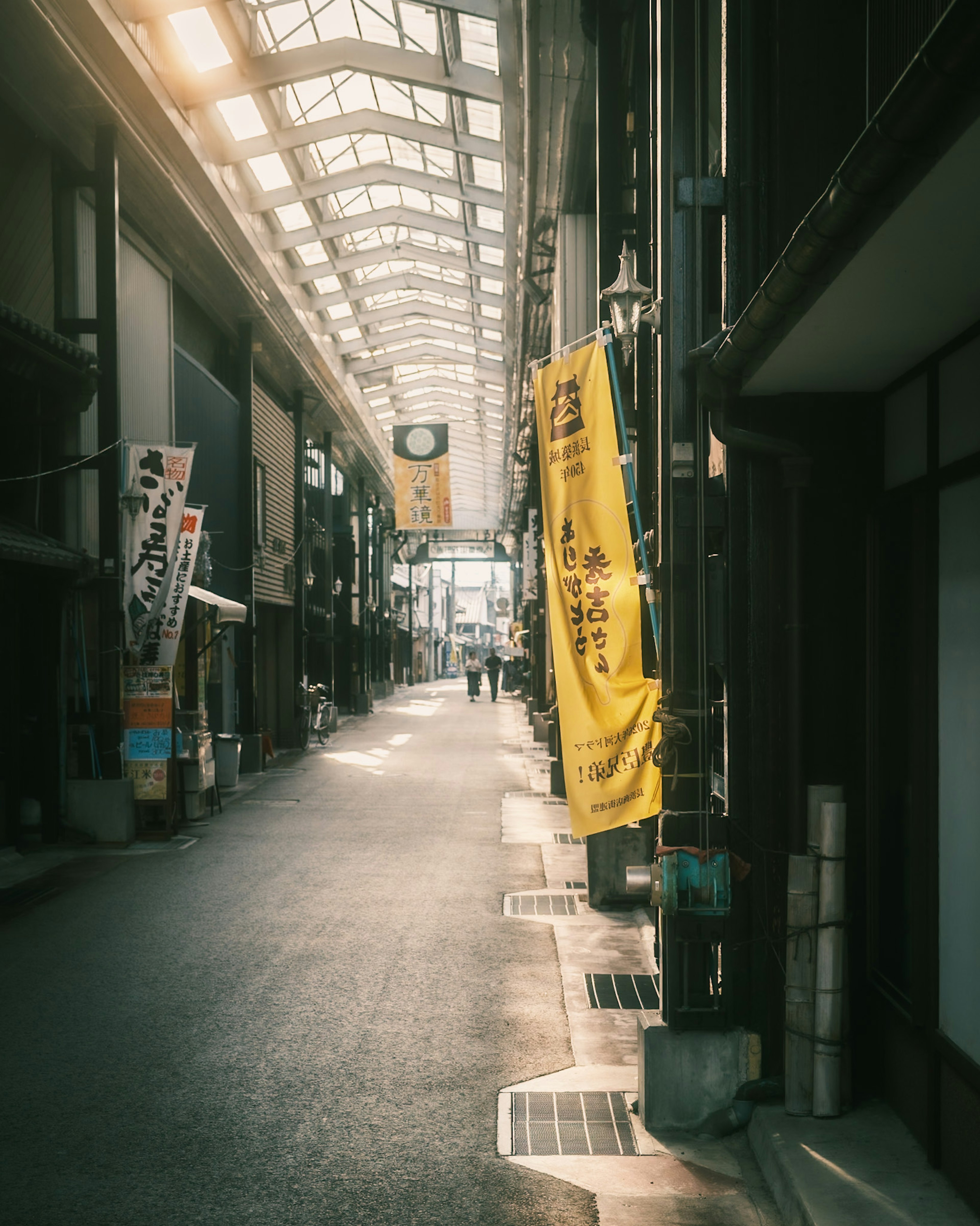 Quiet street scene with a long arcade yellow banners hanging