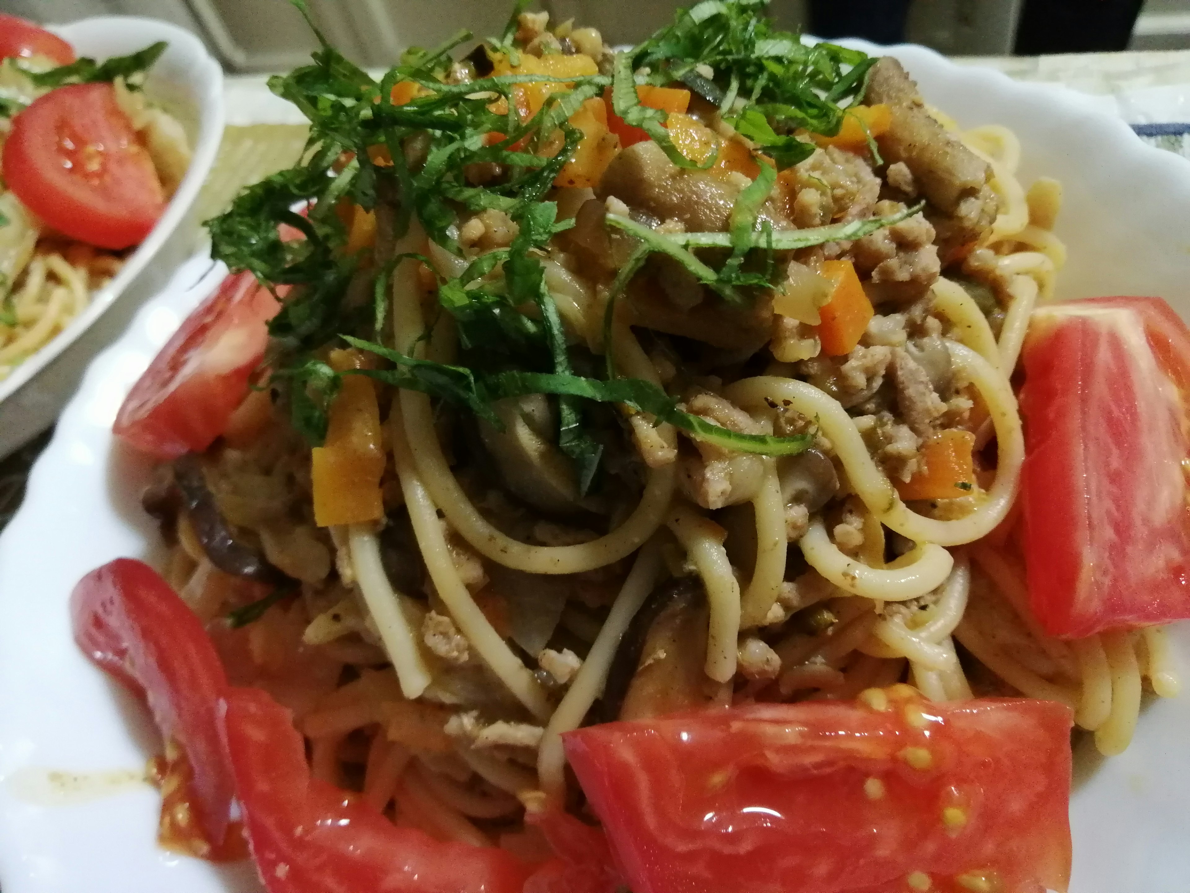 Delizioso piatto di pasta con pomodori e guarnizione di erbe