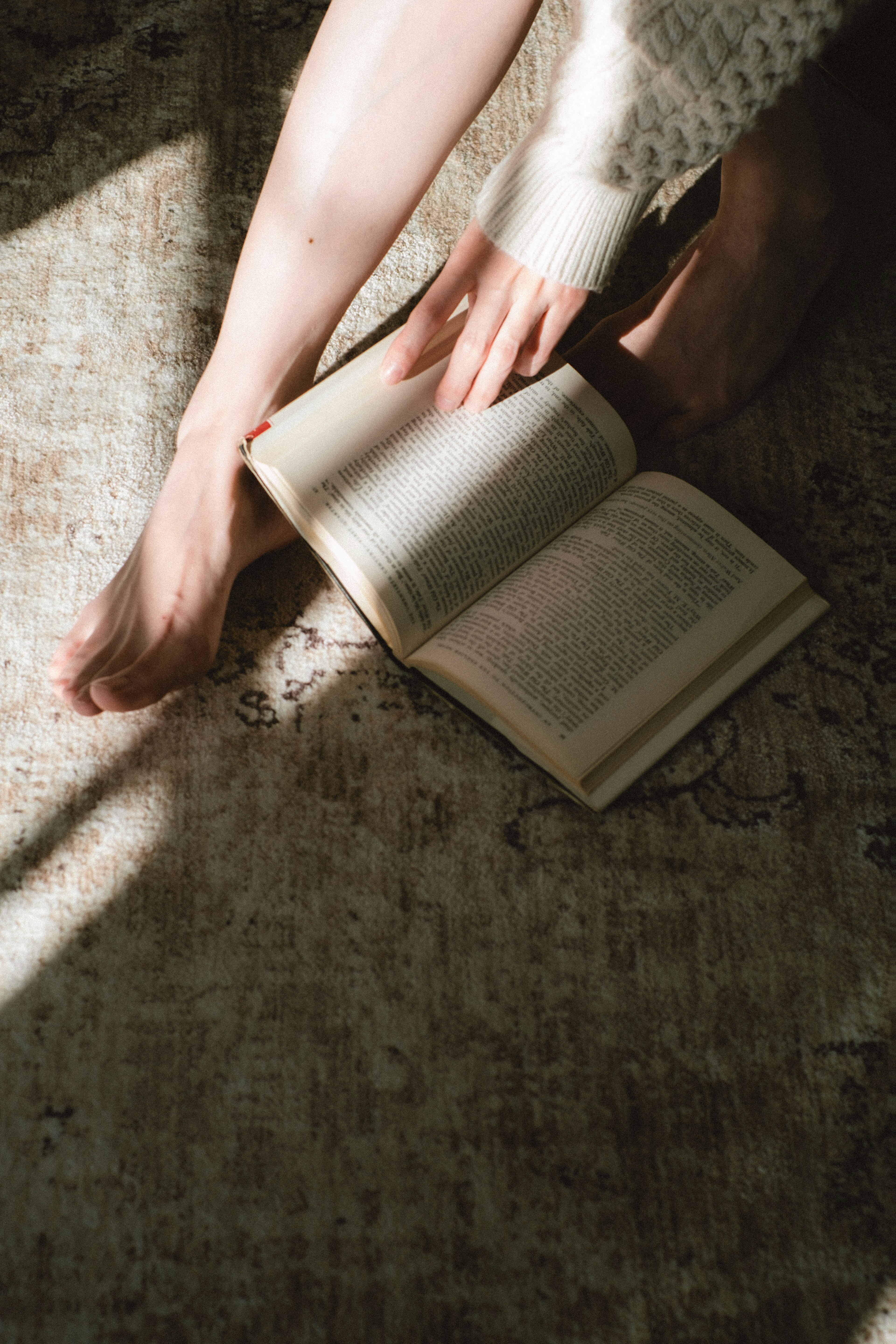 Scène de lecture détendue avec des pieds et un livre ouvert