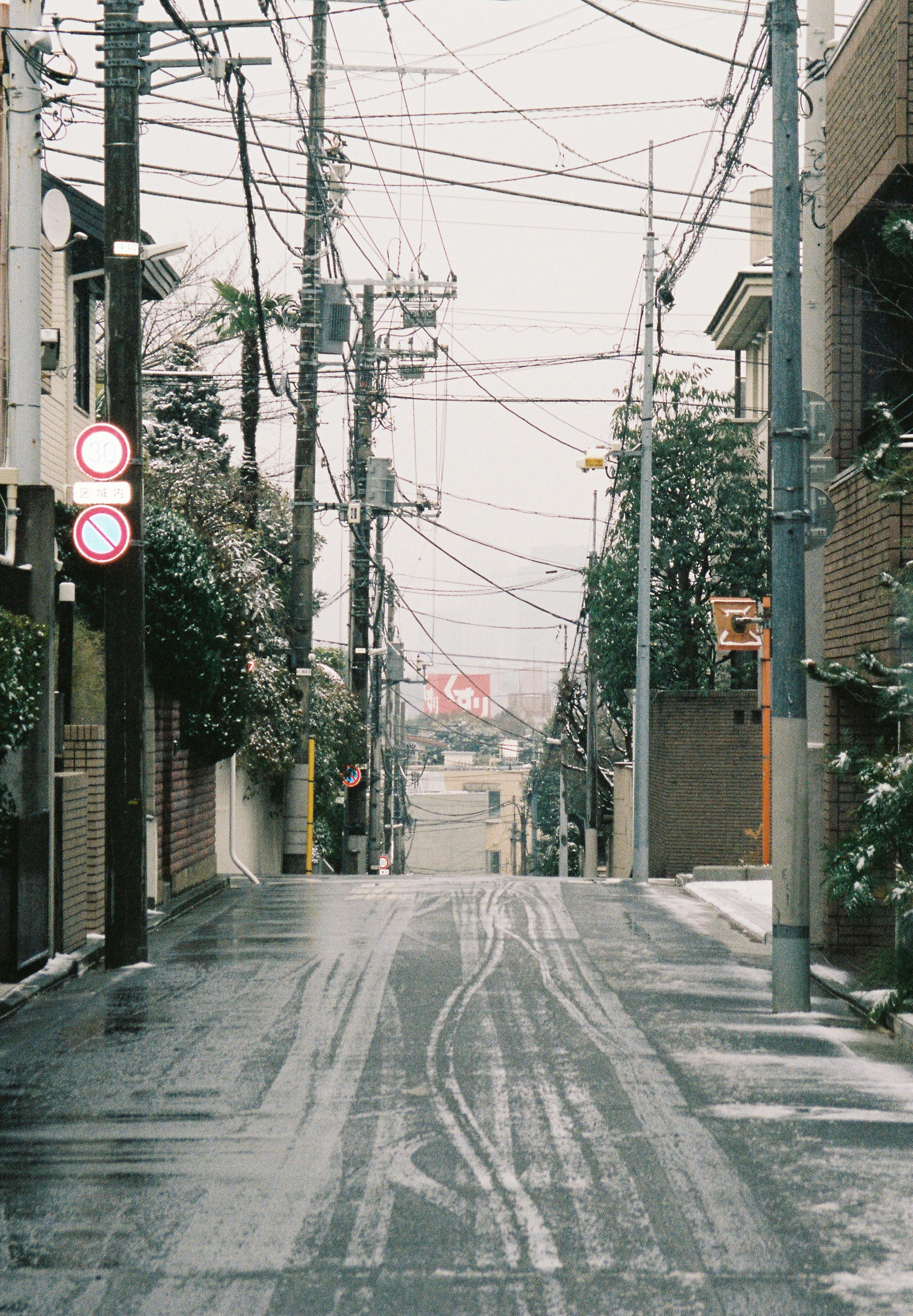 Ruhige, schneebedeckte Straße in Tokio mit Stromleitungen