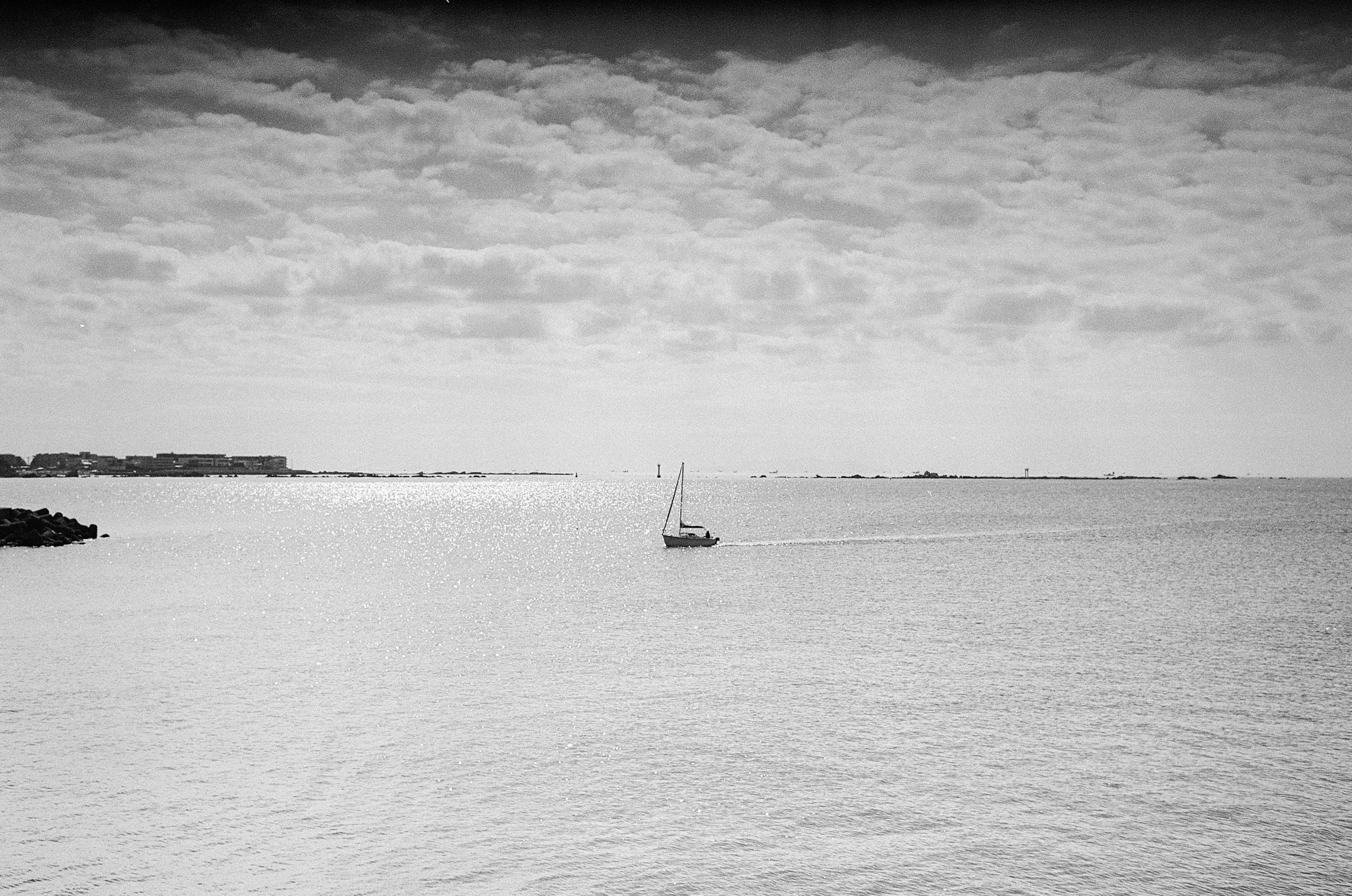 Black and white seascape with a small sailboat floating