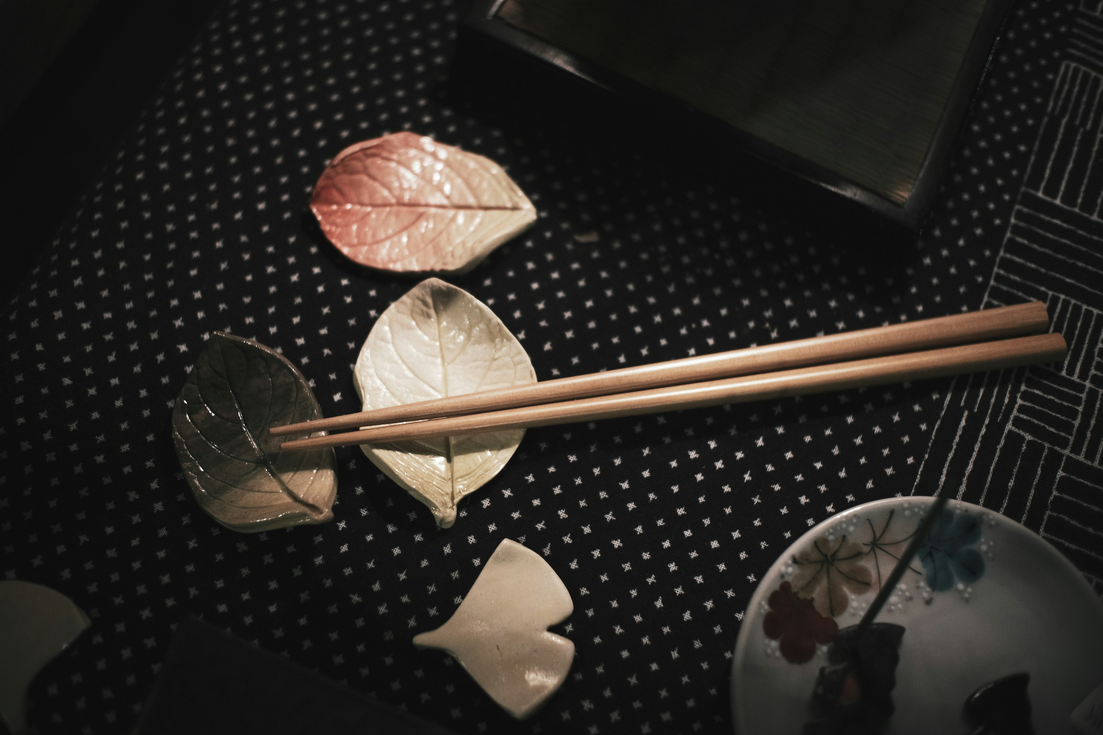 Wooden chopsticks placed over elegant leaf-shaped plates