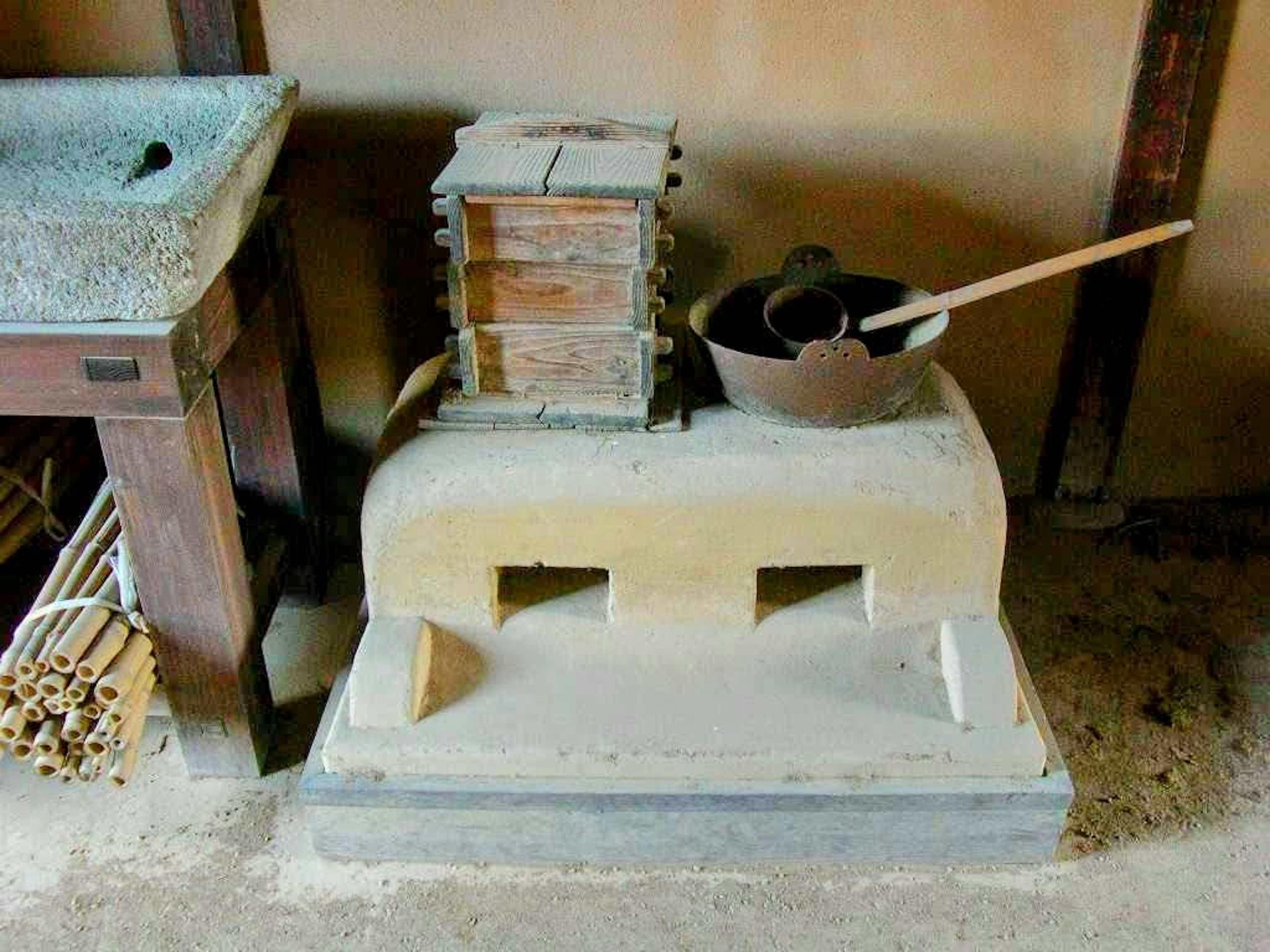 Angolo di cucina giapponese tradizionale con strumenti di cottura in pietra e utensili in legno