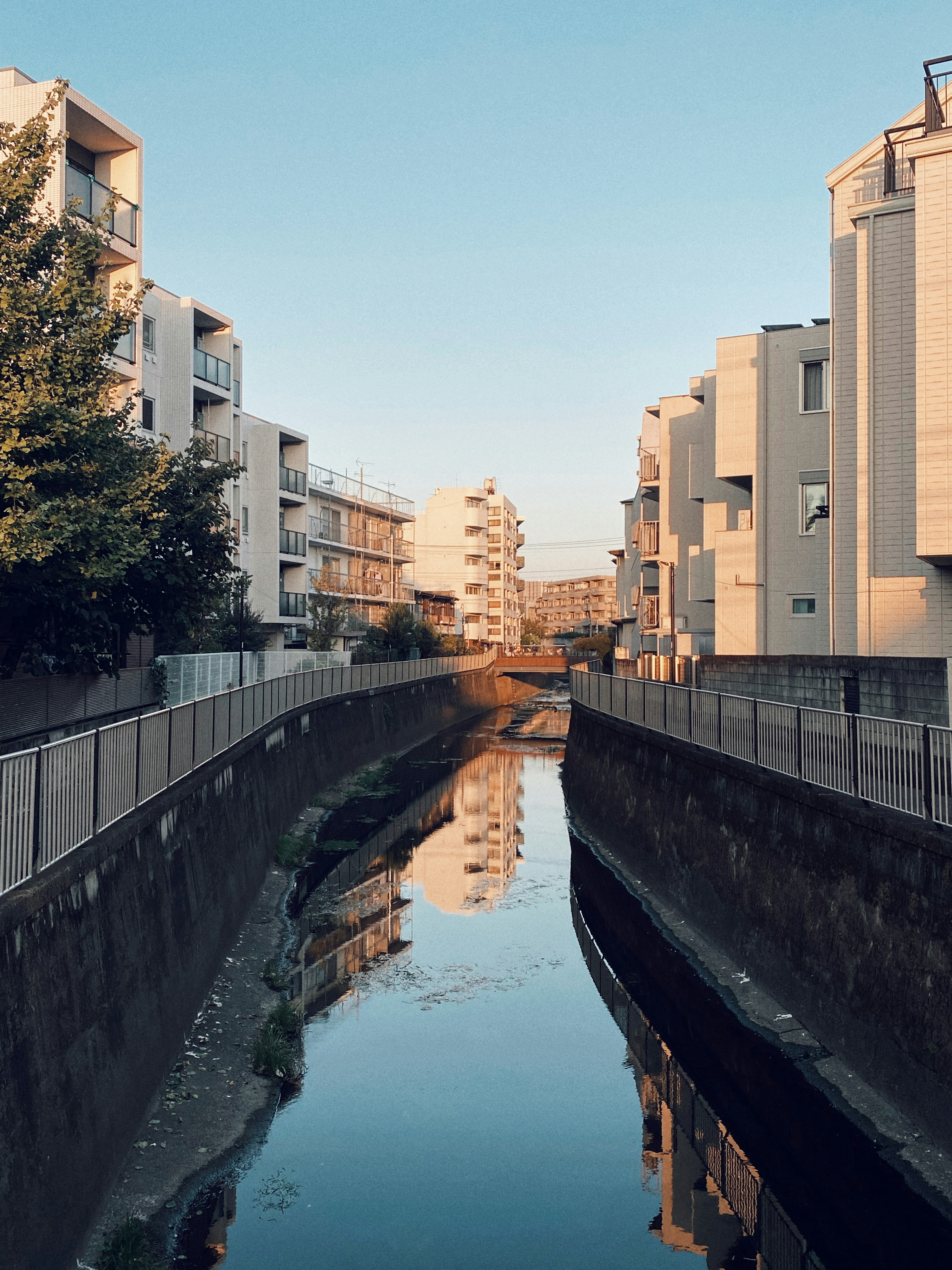 Calm canal flowing between residential buildings with reflections