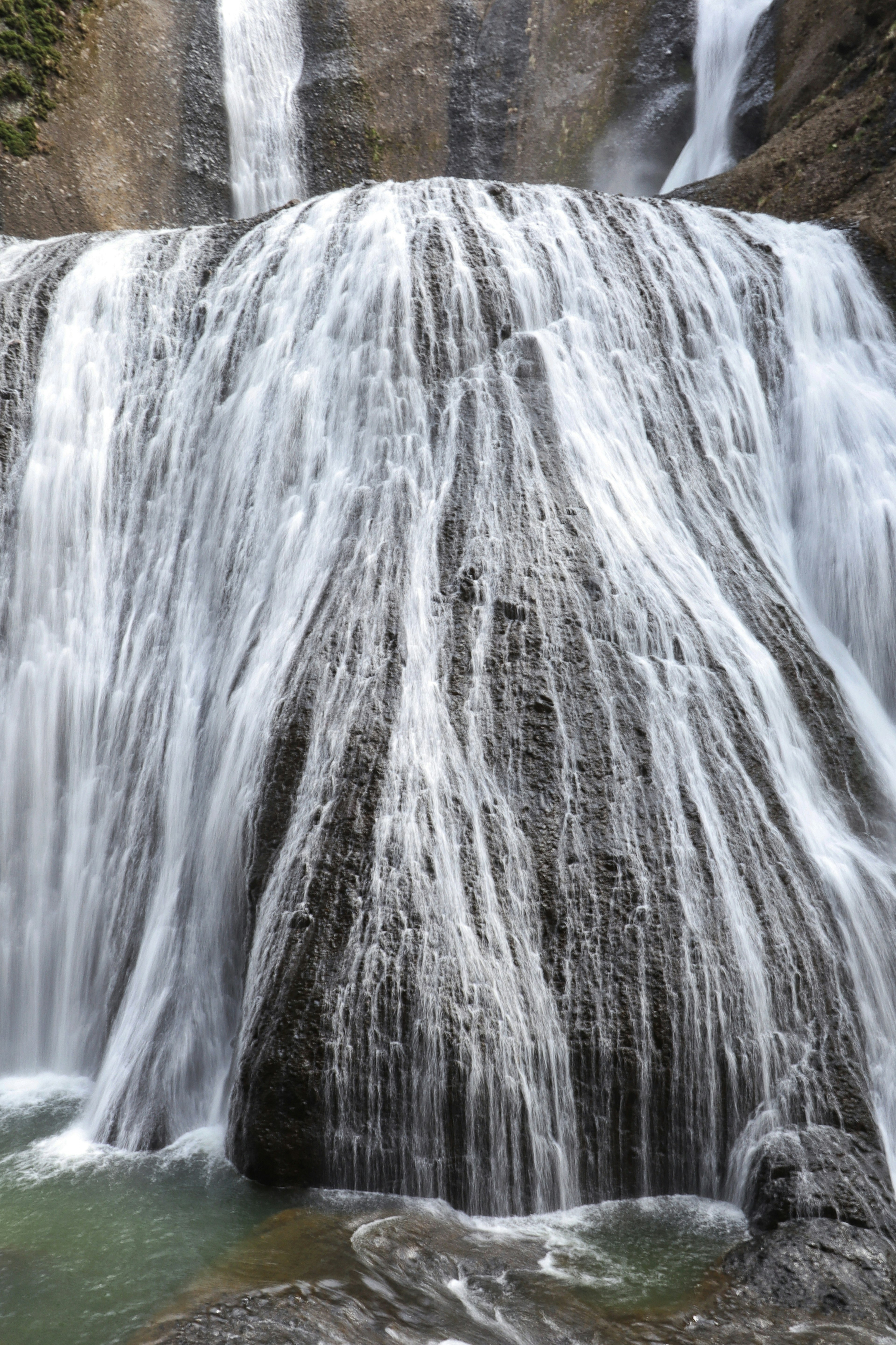 Smooth water cascading down a waterfall with rocky surface details