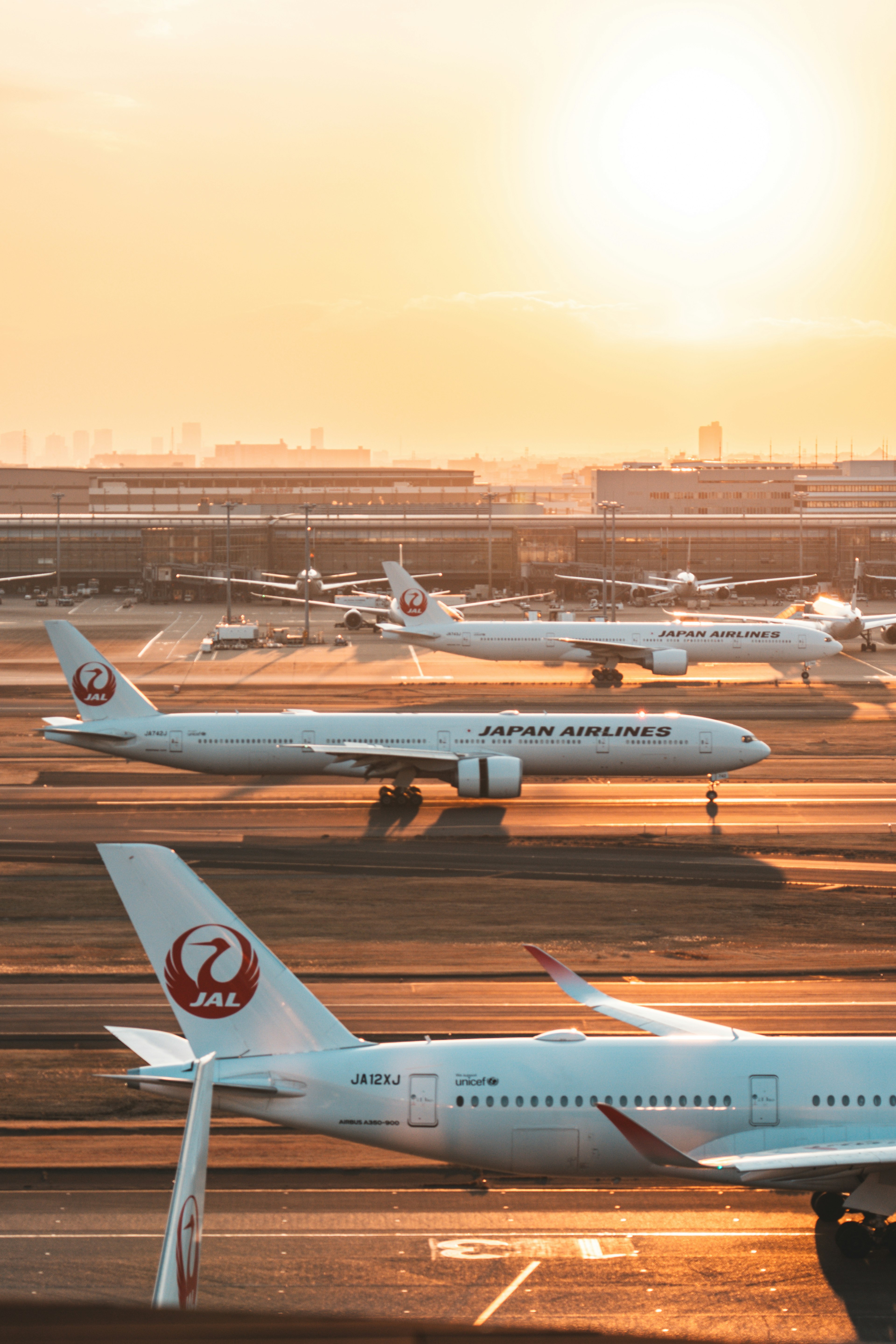 Plusieurs avions sur un aéroport au coucher du soleil avec une lueur chaude