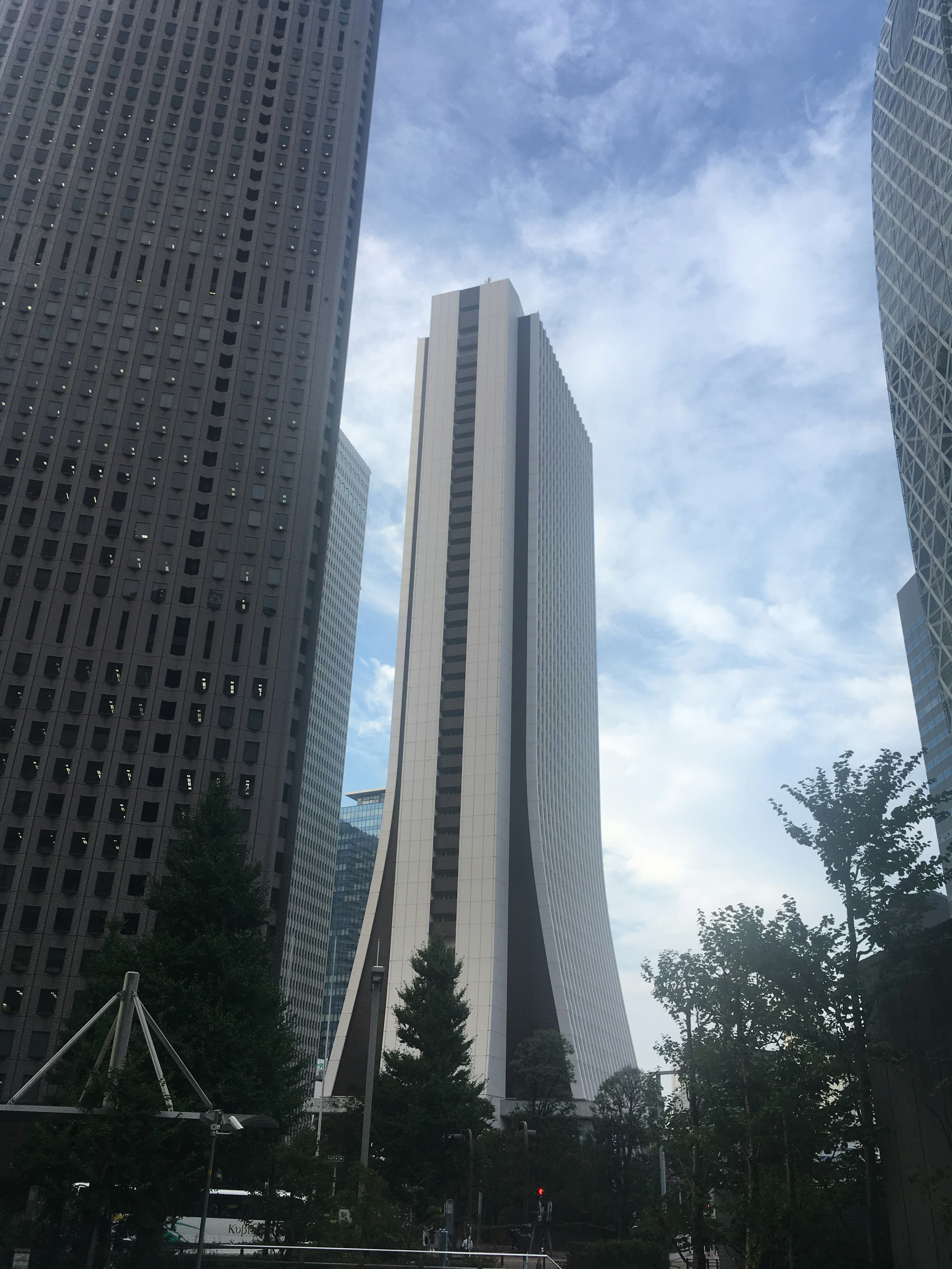 Einzigartig gestalteter Wolkenkratzer umgeben von modernen Gebäuden in einer Stadtlandschaft