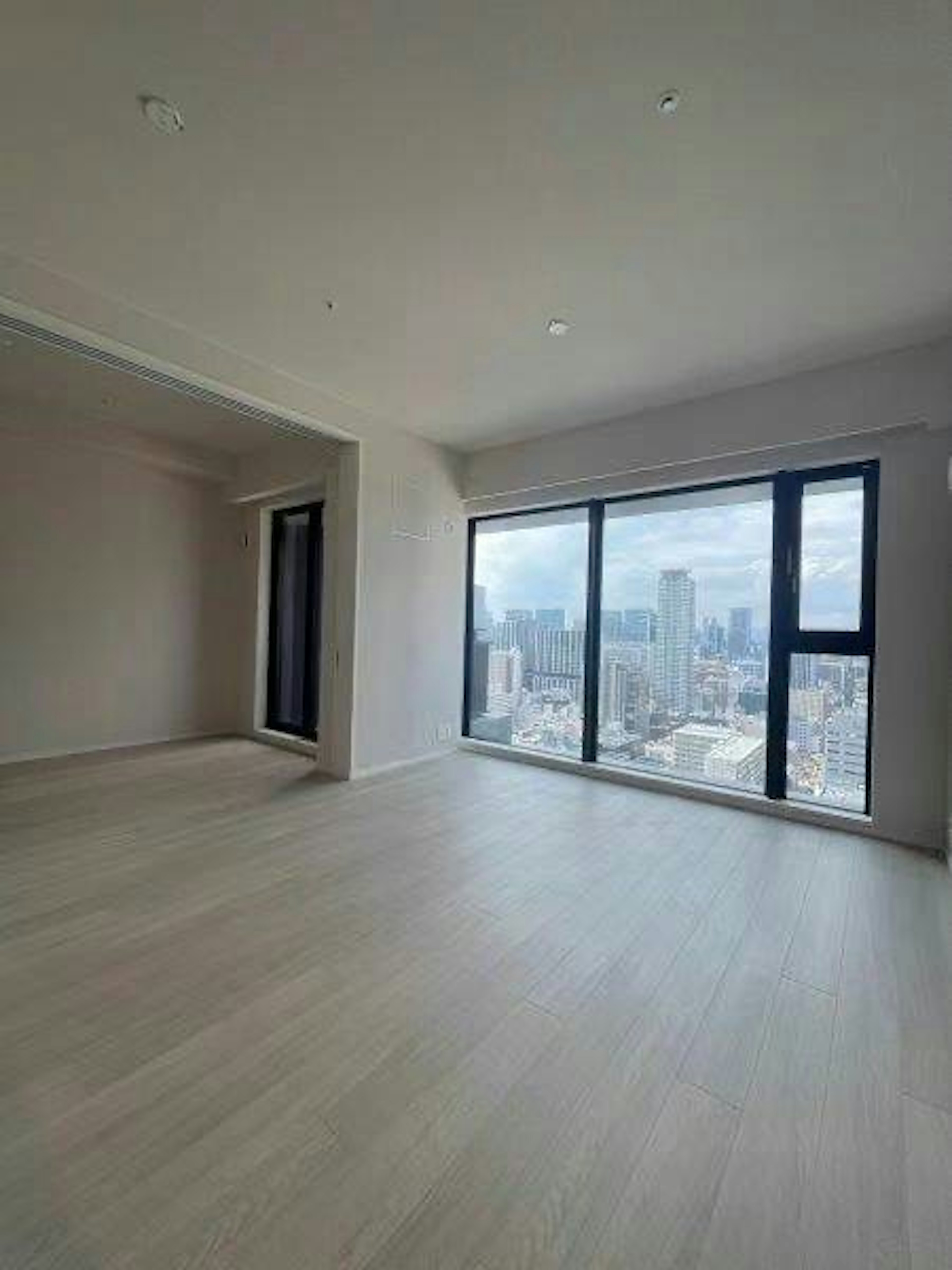 Spacious bright room with large windows showcasing a city view