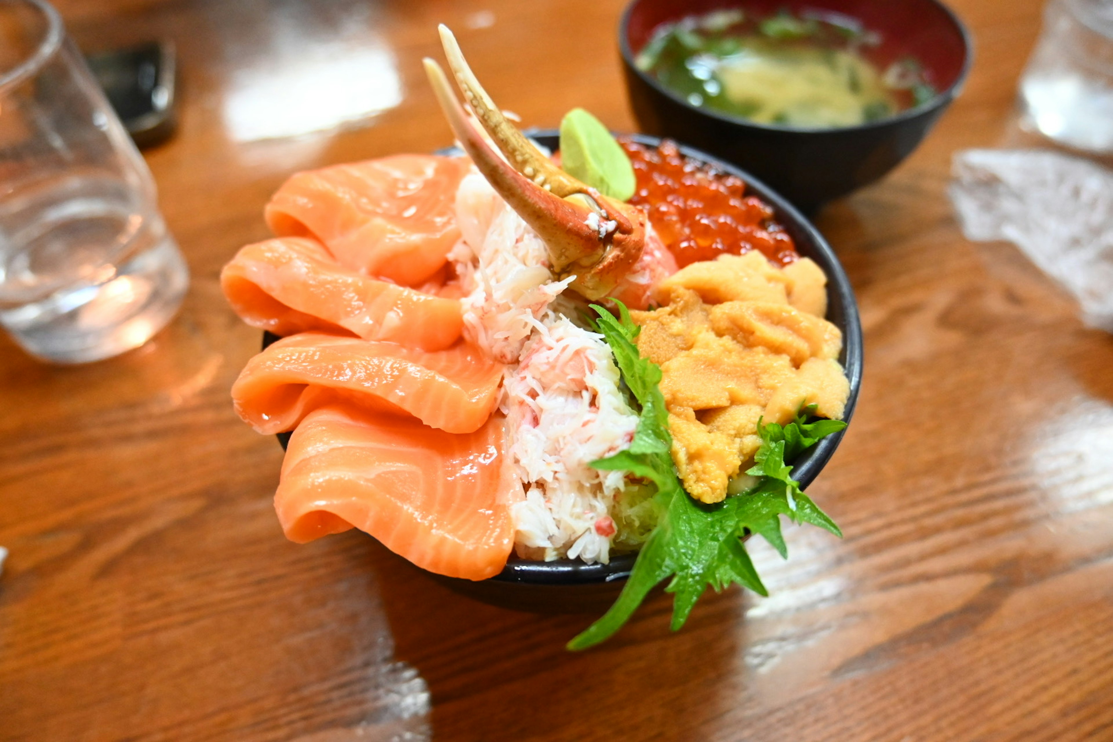 Sashimi bowl topped with salmon, crab, sea urchin, and salmon roe