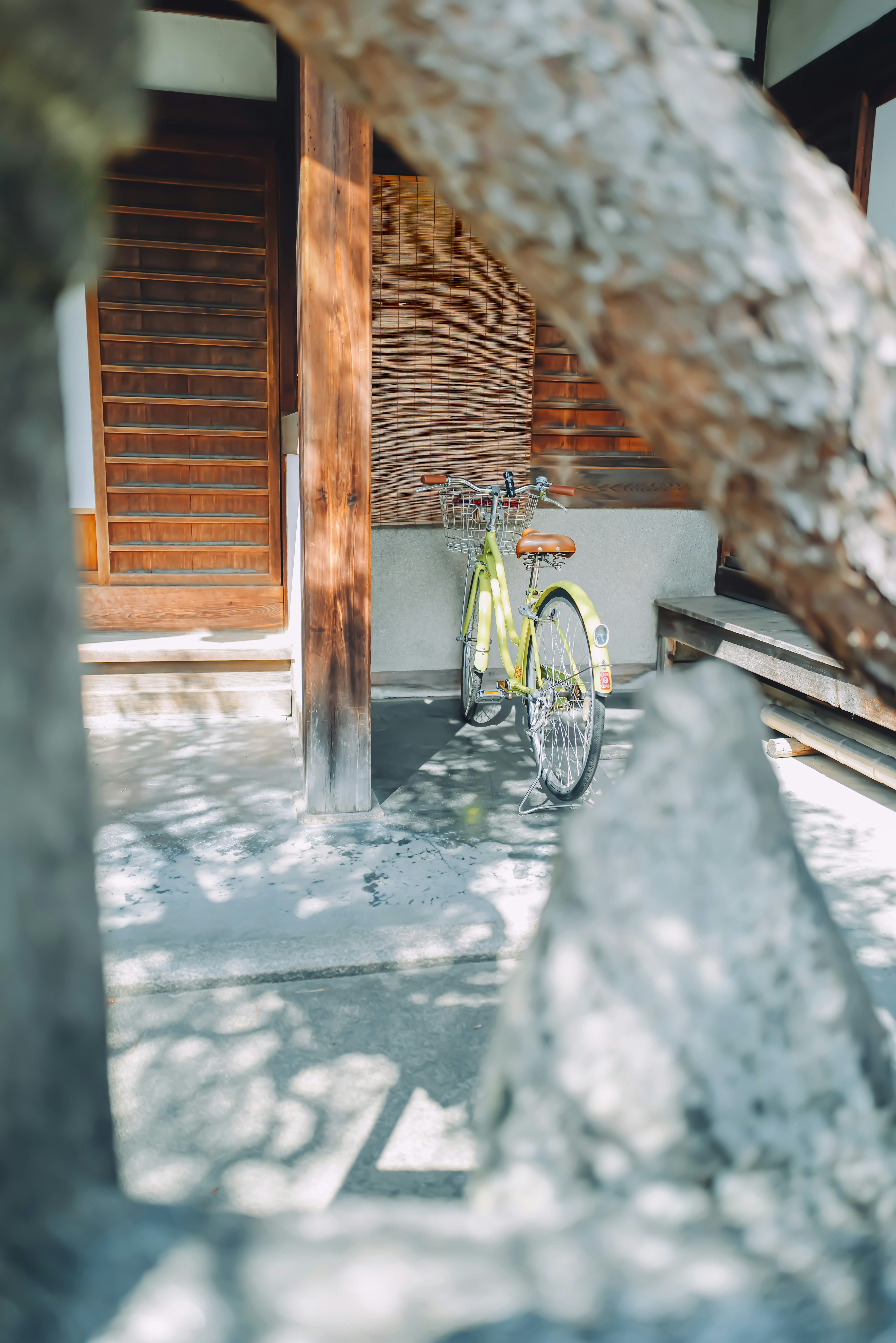 A green bicycle parked in a traditional Japanese home courtyard with wooden features