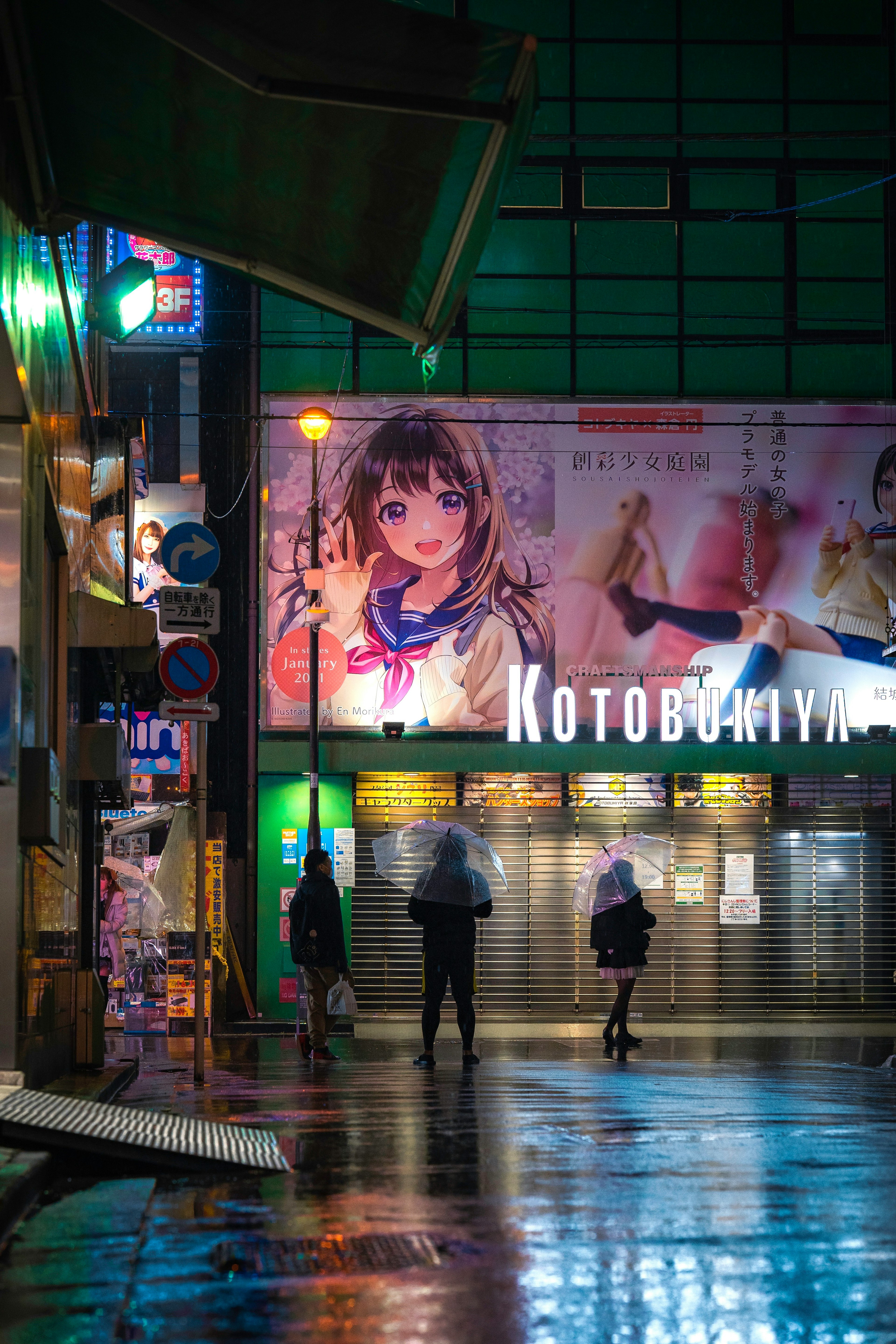 雨の中で輝くネオンとアニメの看板のある街角