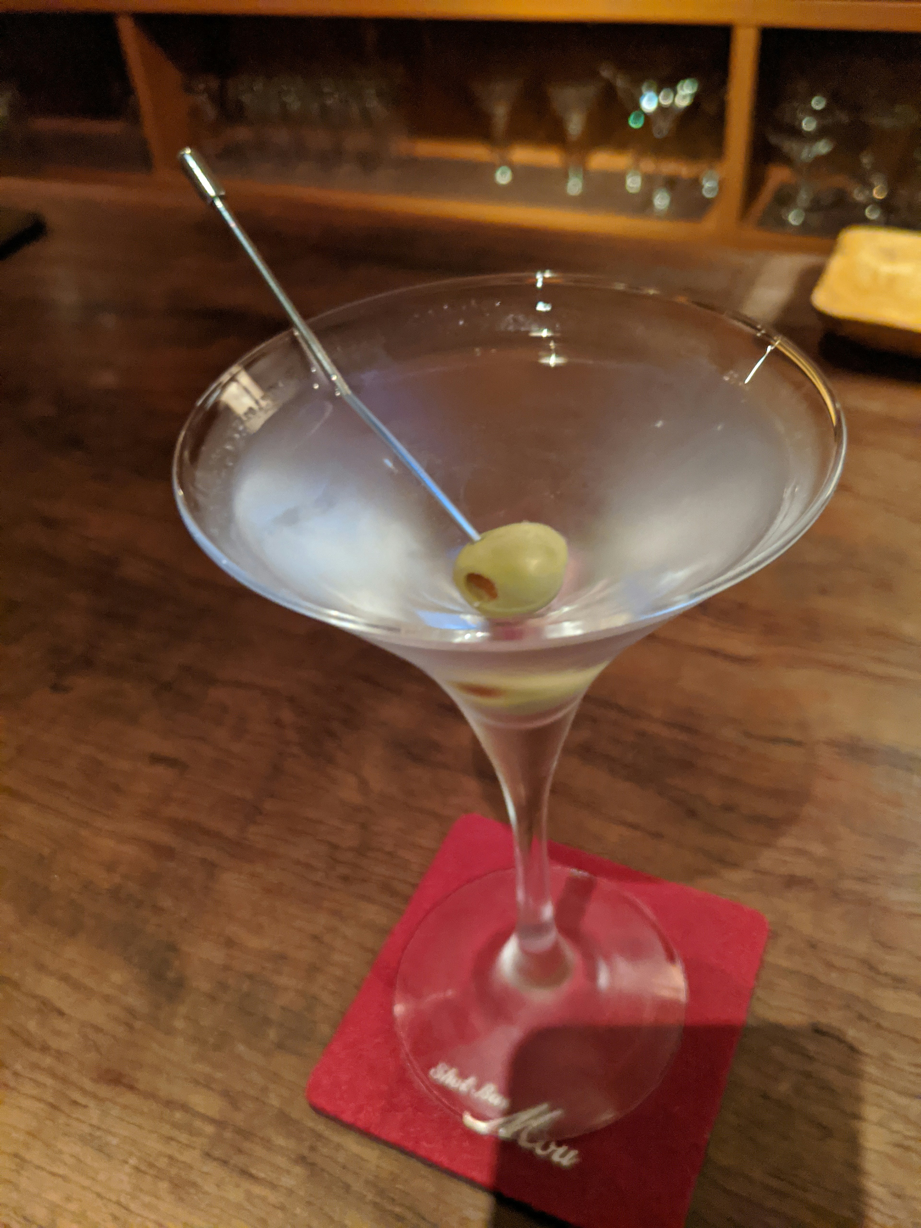 Martini cocktail with an olive served in a glass