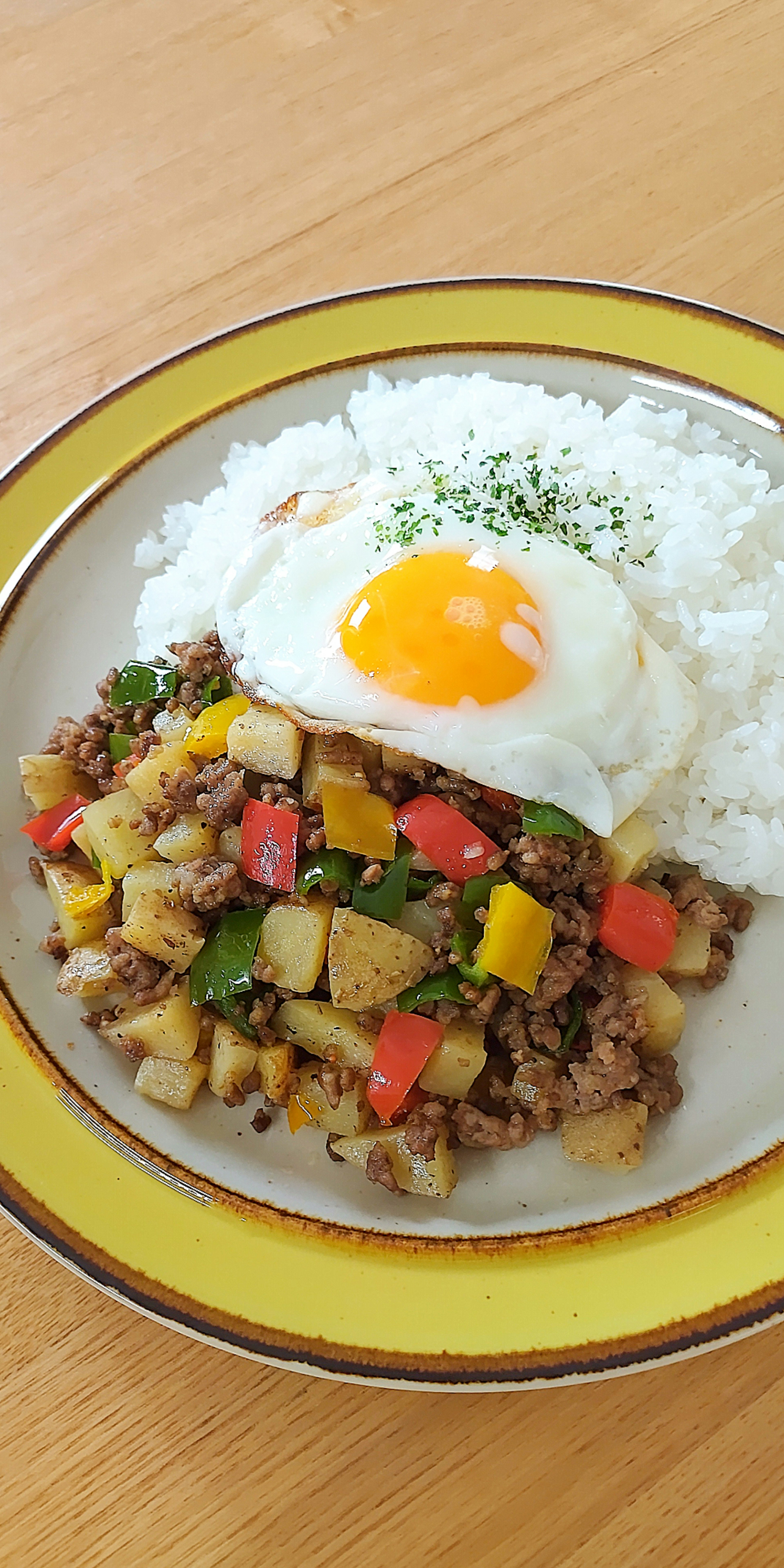 Une assiette de riz surmontée d'un œuf au plat et de légumes colorés