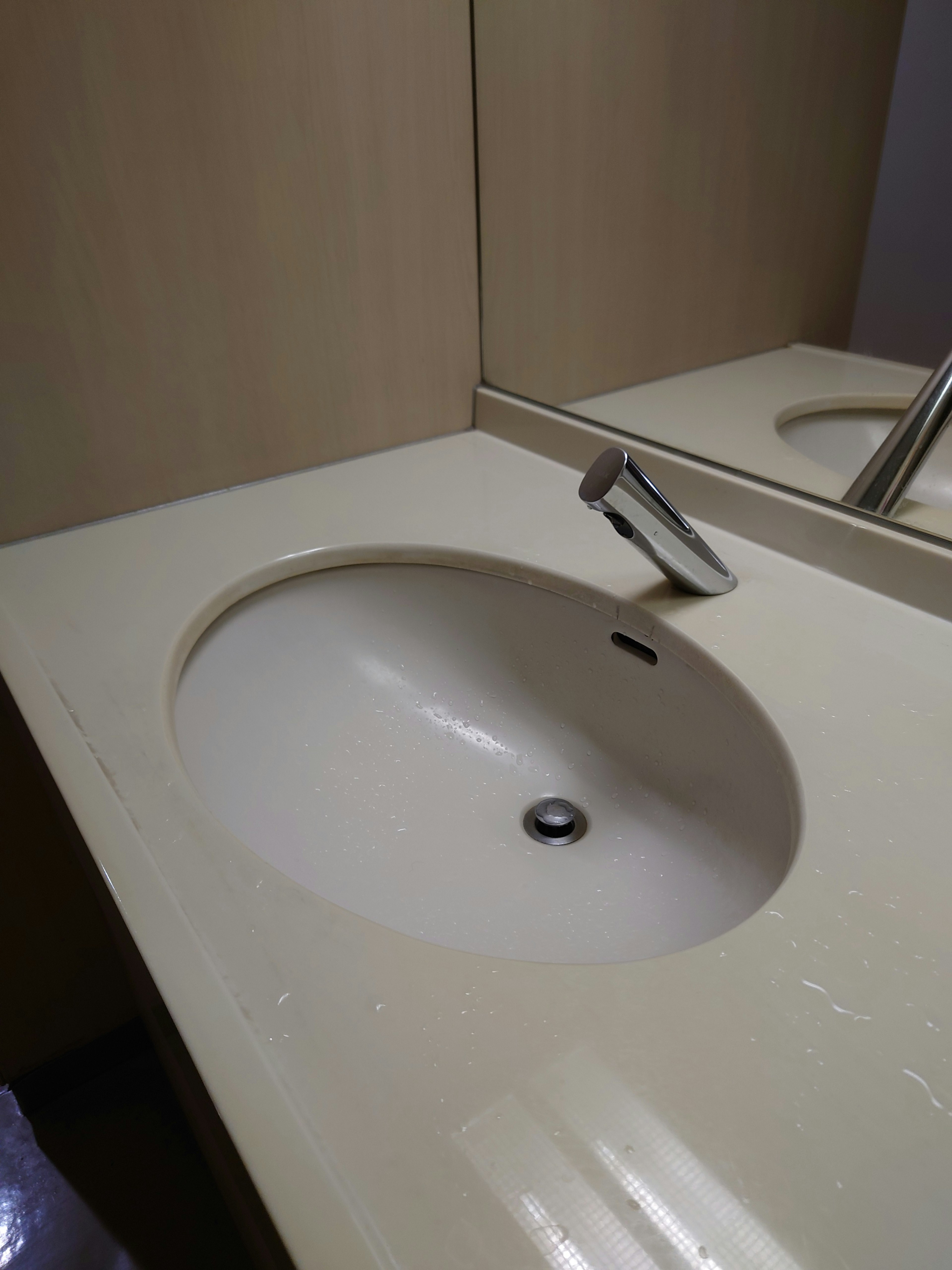 Simple bathroom counter with a white sink and metal faucet