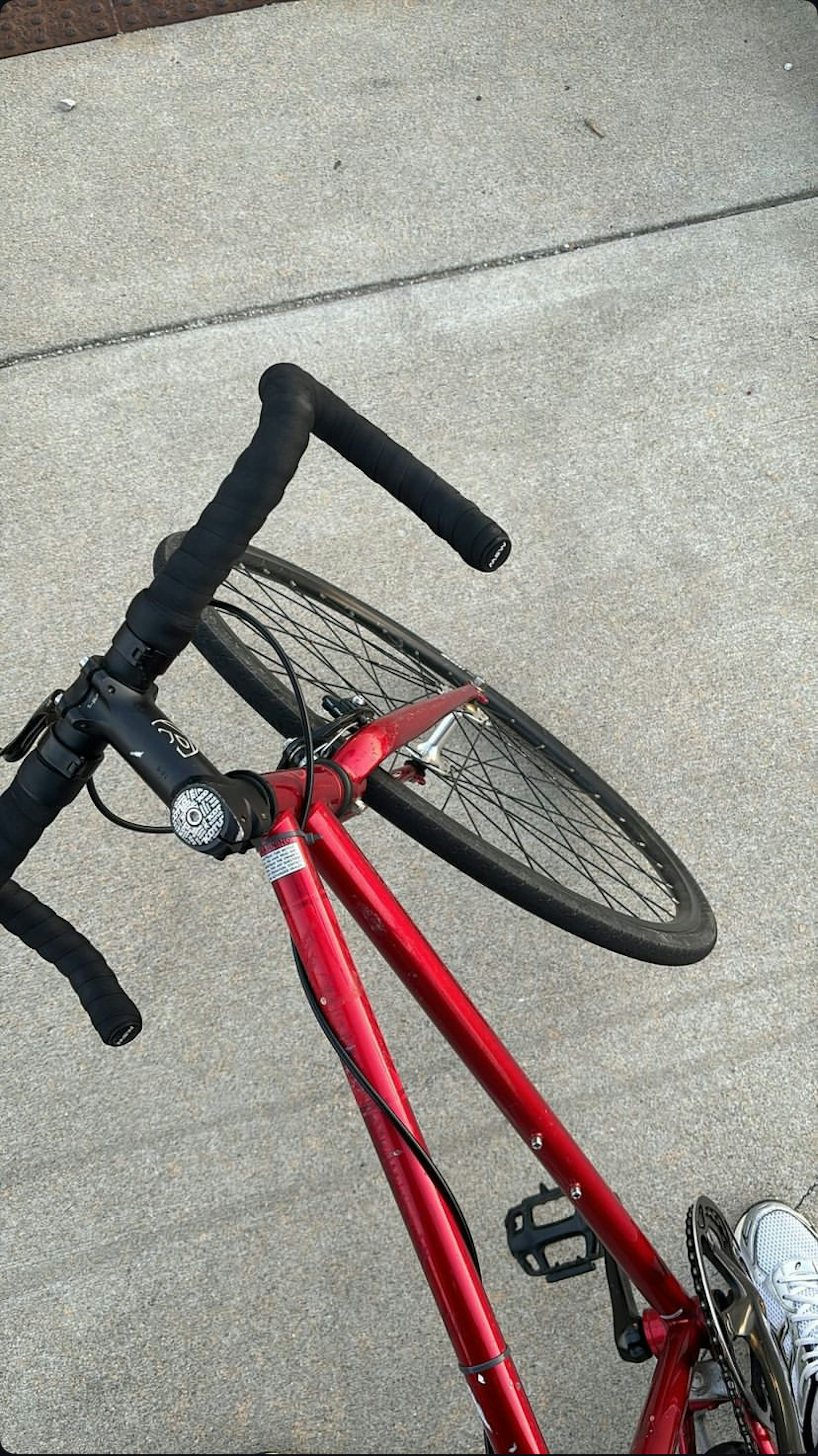 赤い自転車のハンドルとタイヤが映っている