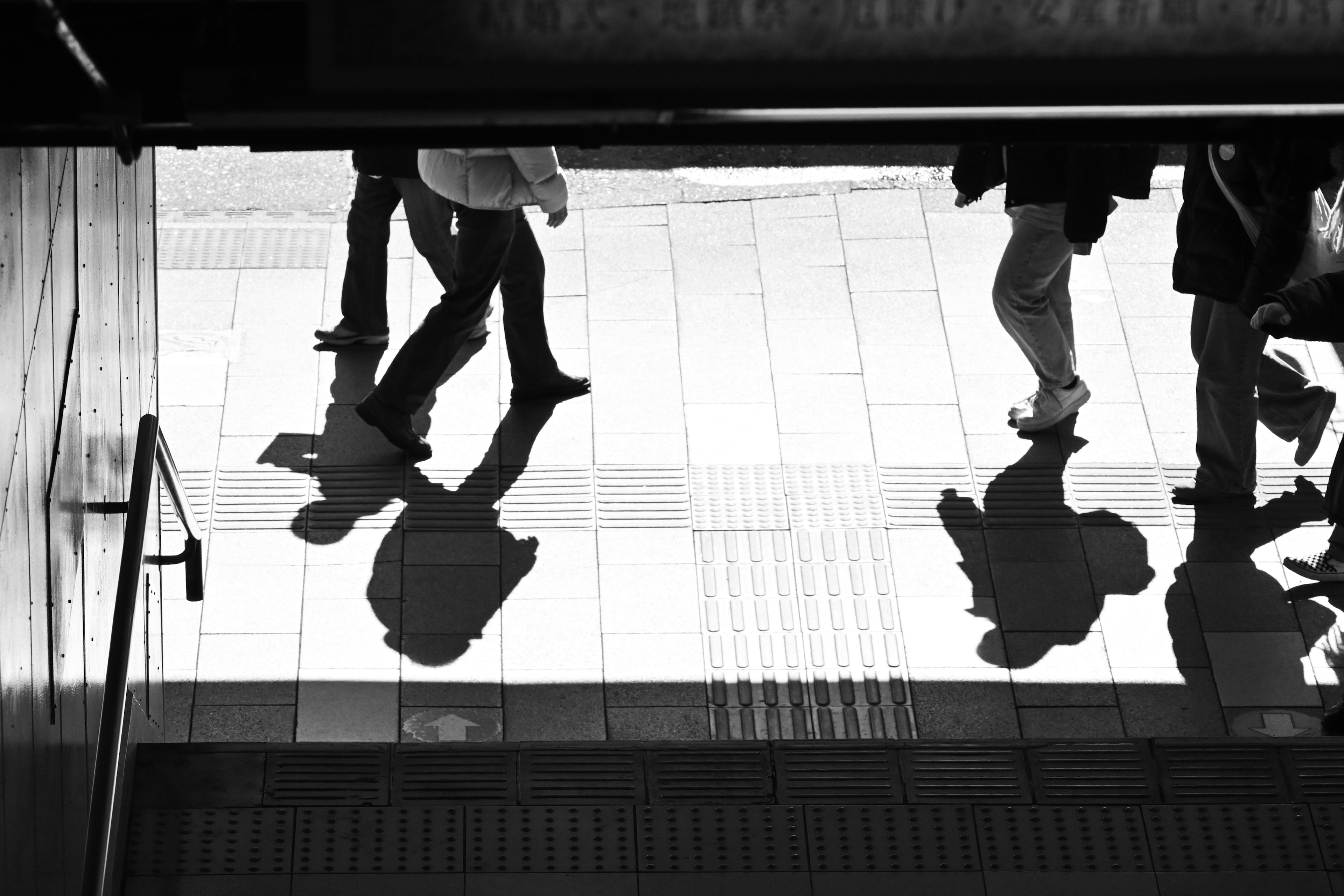 Siluetas de personas caminando en una ciudad en blanco y negro