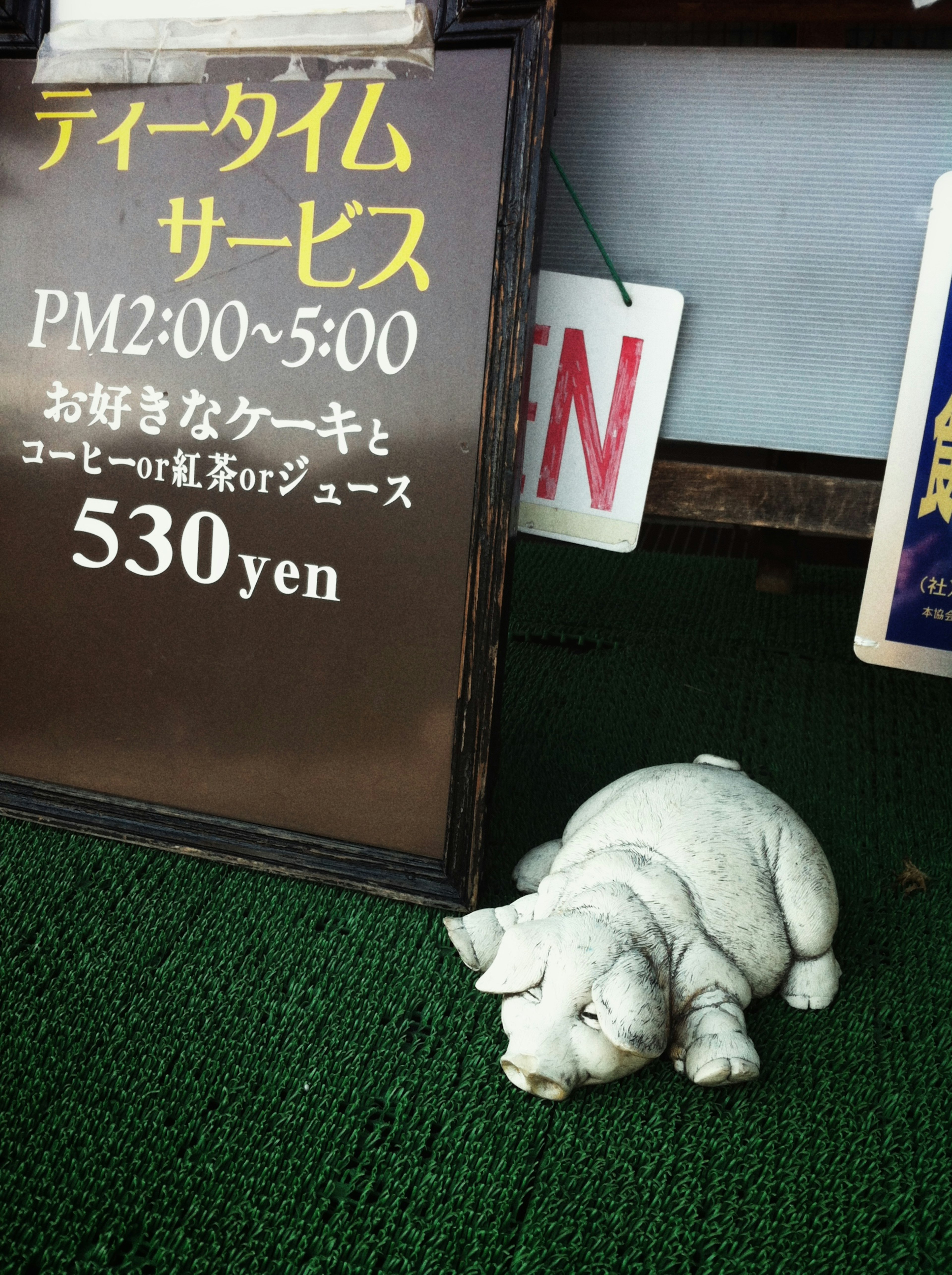 Papan layanan teh dengan patung anjing yang sedang tidur