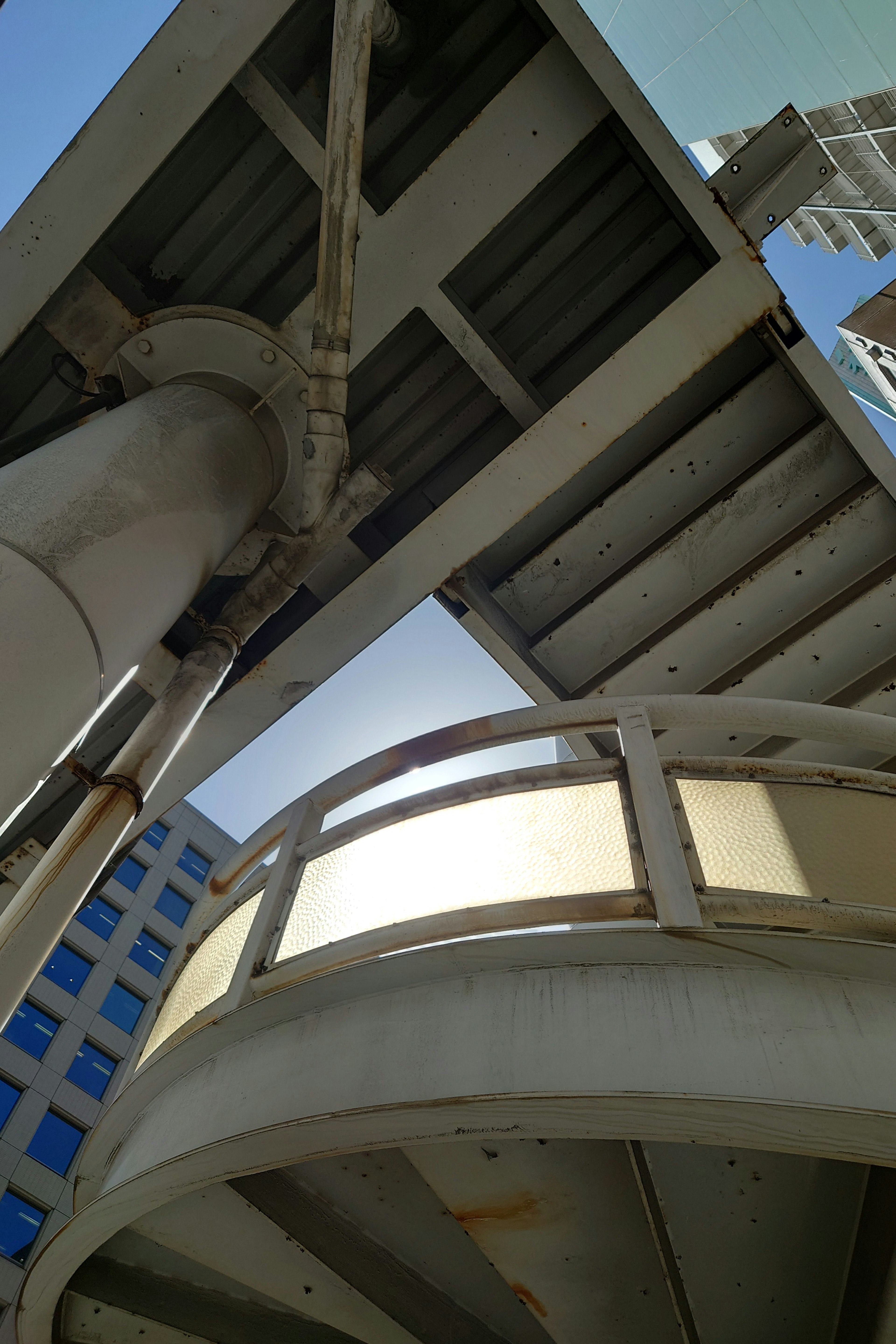 Photo of a structure viewed from below featuring a complex handrail design and overhead beams