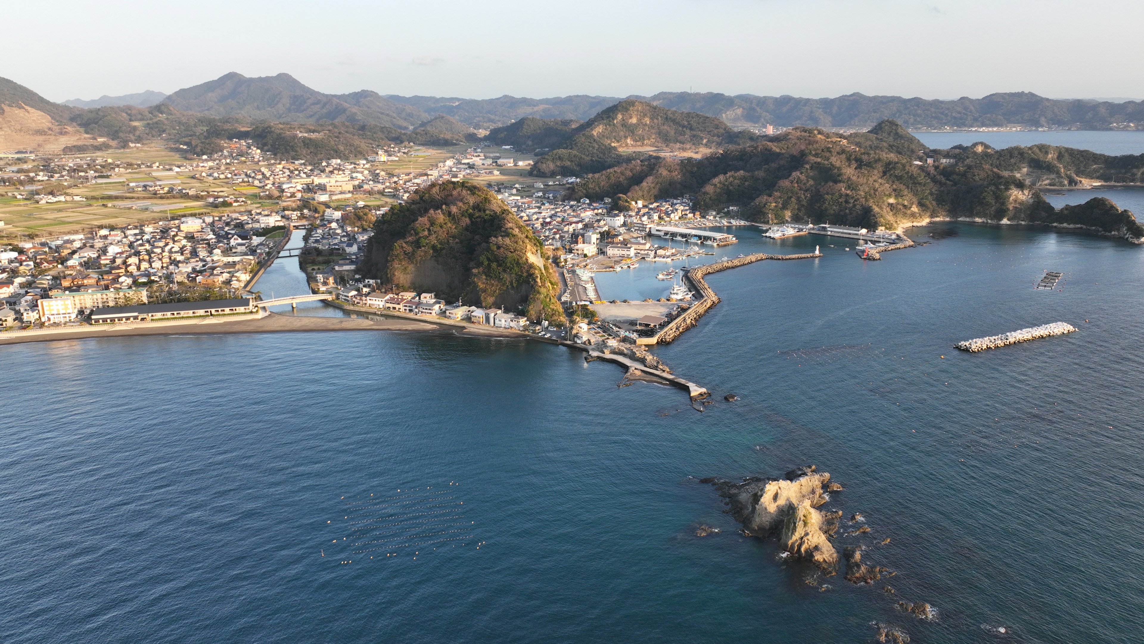 Aerial view of a coastal town with rocky formations and calm waters