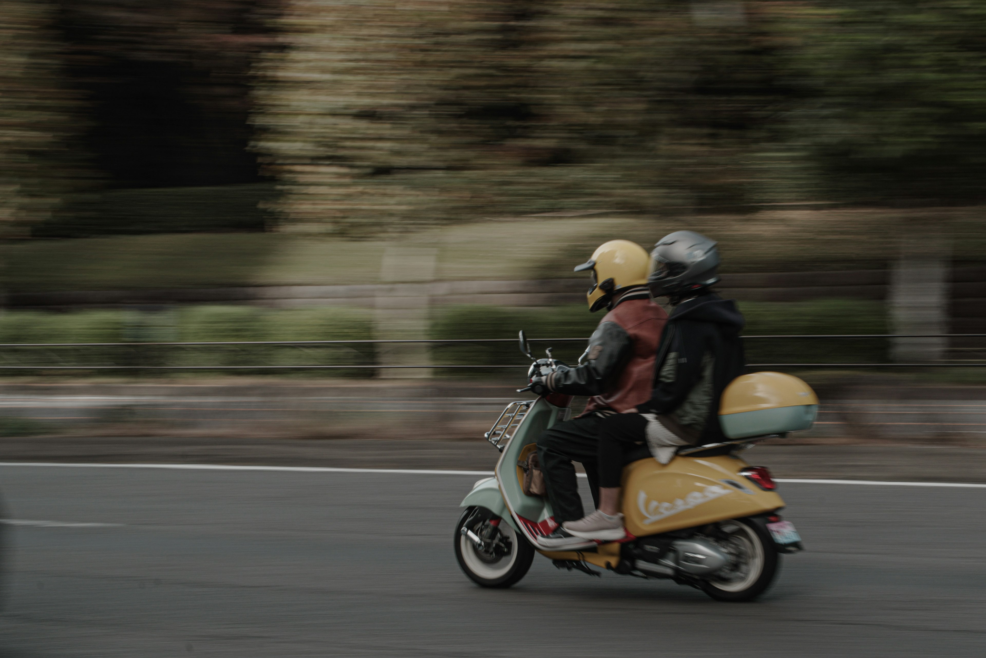 Due persone che guidano uno scooter in movimento