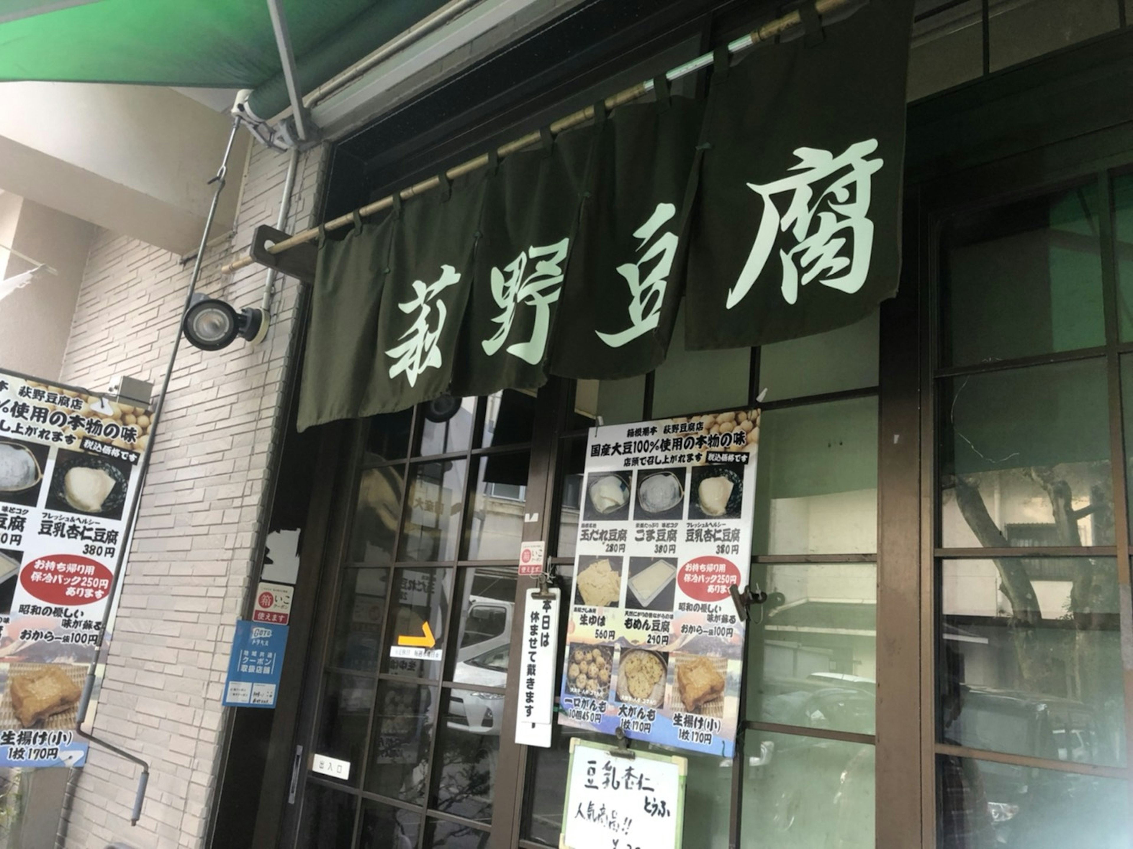 Außenansicht eines japanischen Restaurants mit grünem Schild und Kanji-Zeichen