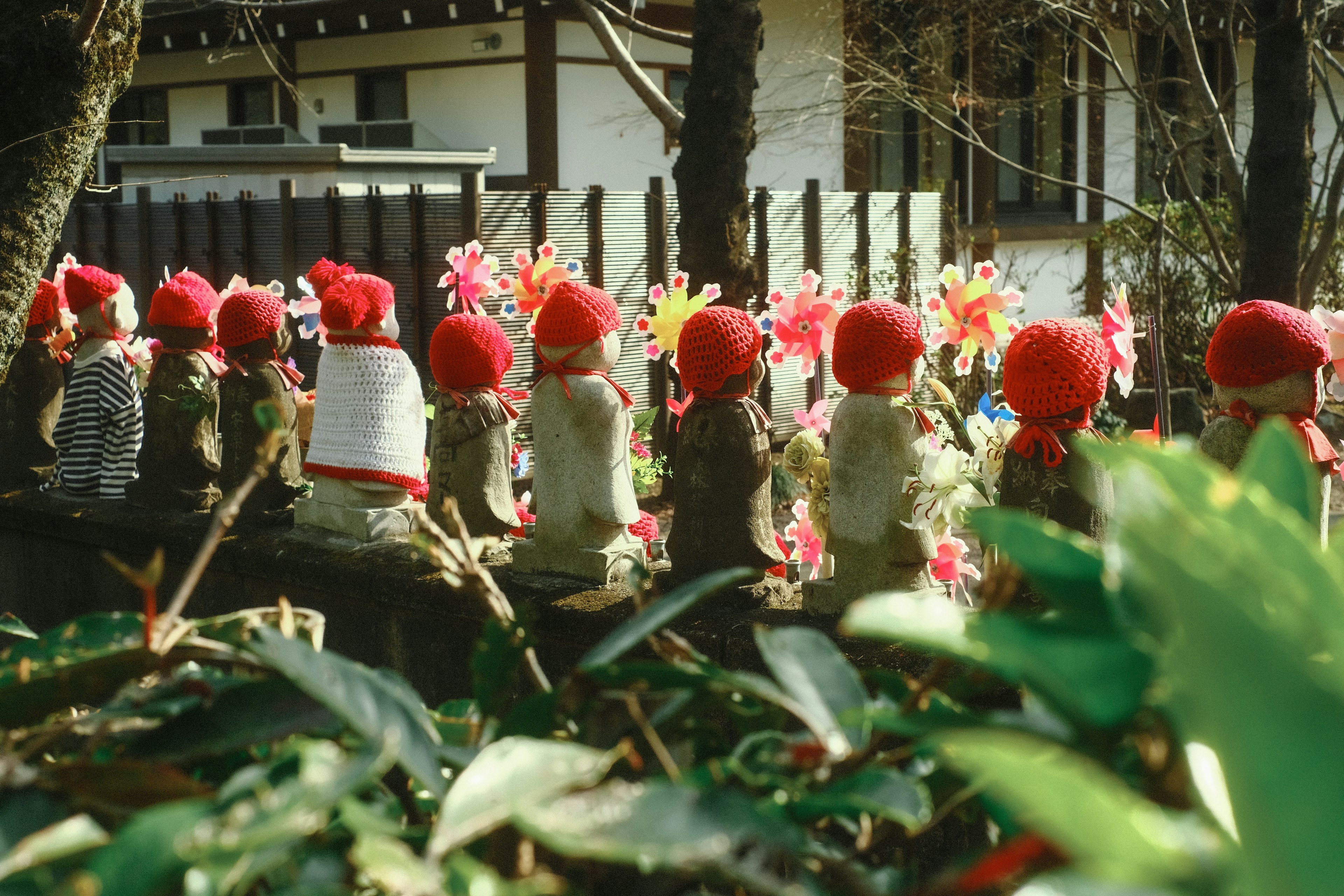 Rangée de petites poupées portant des chapeaux rouges avec des fleurs colorées en arrière-plan