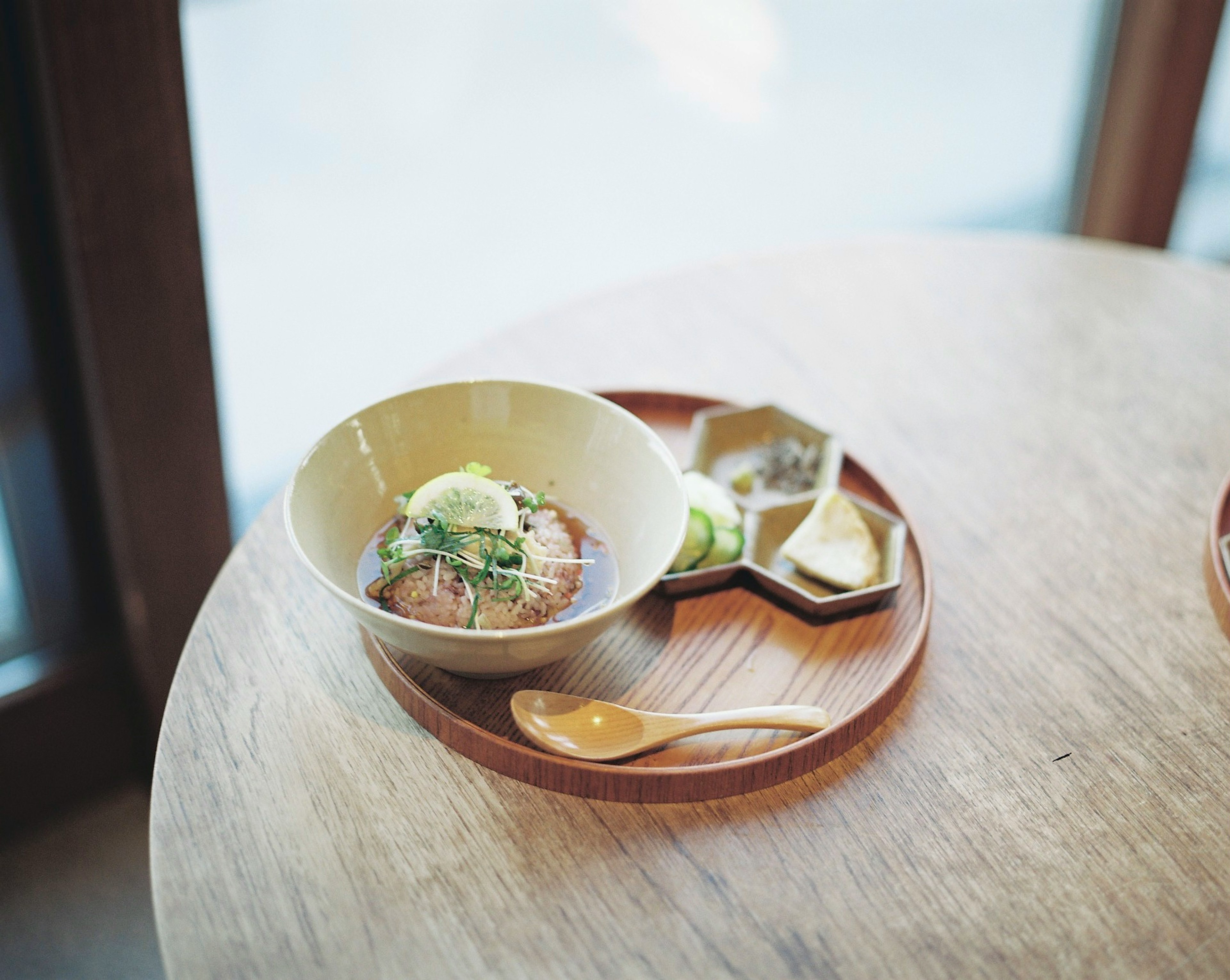 A wooden tray with a Japanese meal plate and small dishes