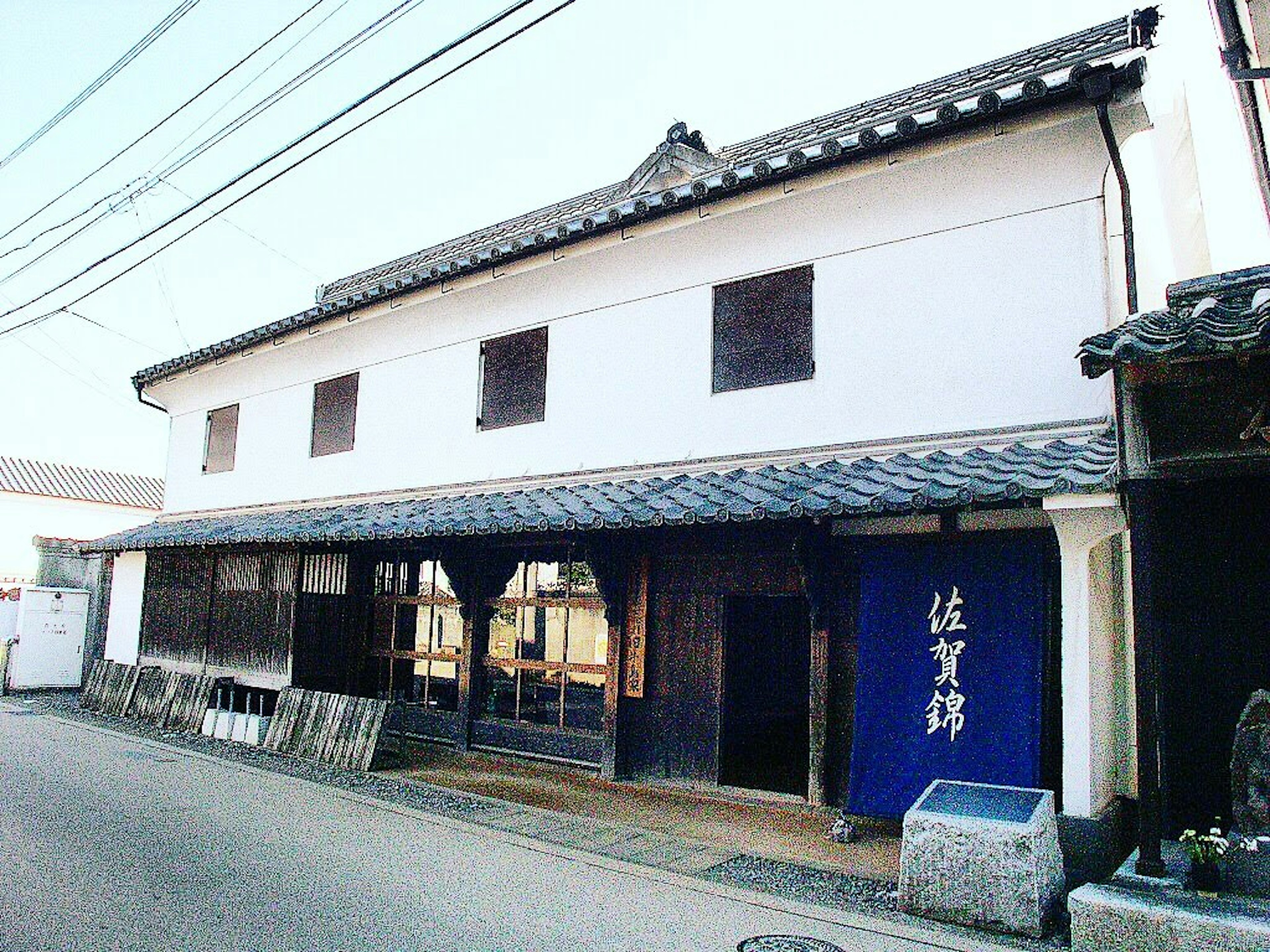 传统日本建筑外观 白色墙壁和黑色屋顶 位于街道旁