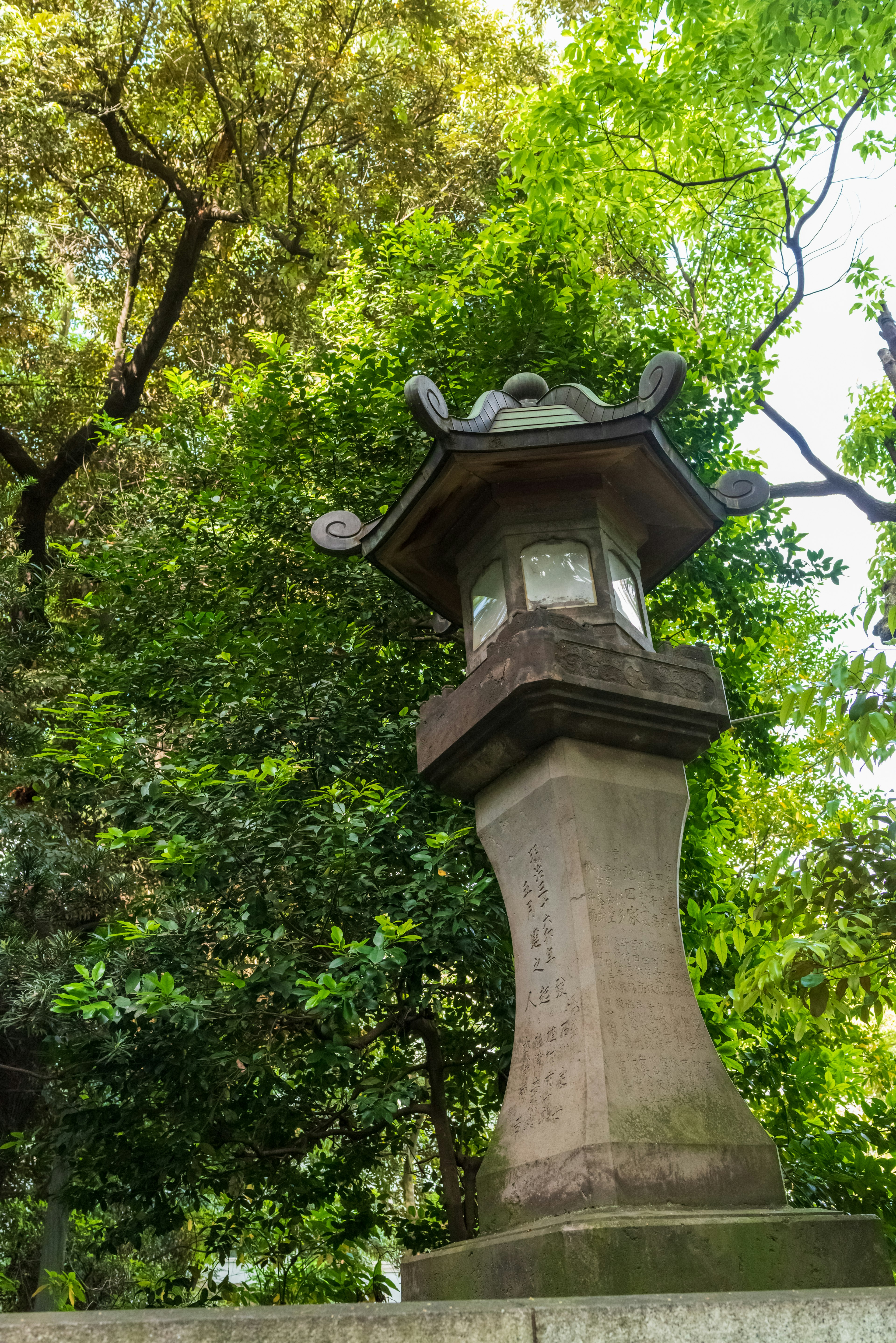 日本庭園中的石燈籠，背景為郁郁蔥蔥的綠色