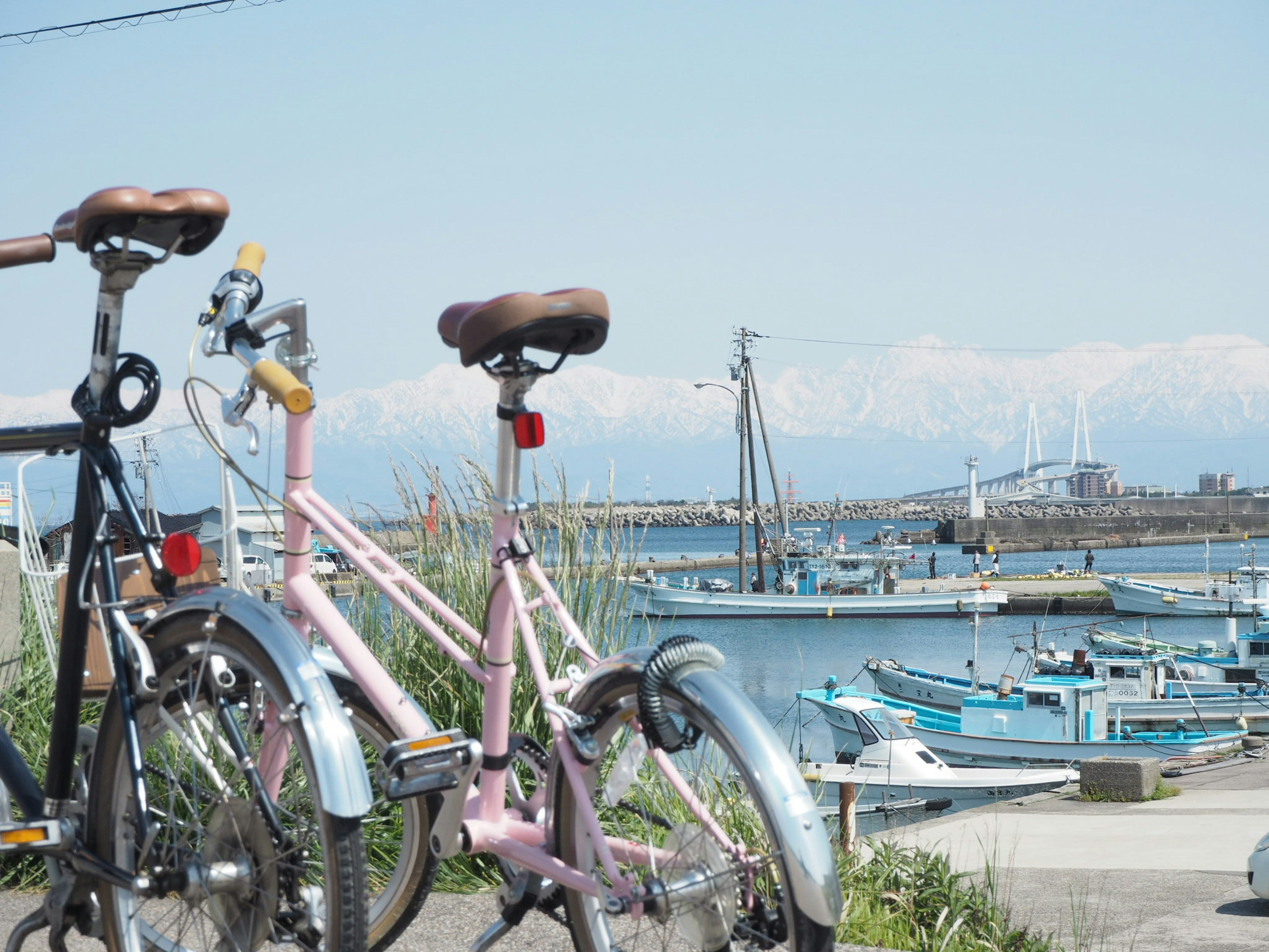 Vélos au premier plan avec des bateaux et des montagnes en arrière-plan