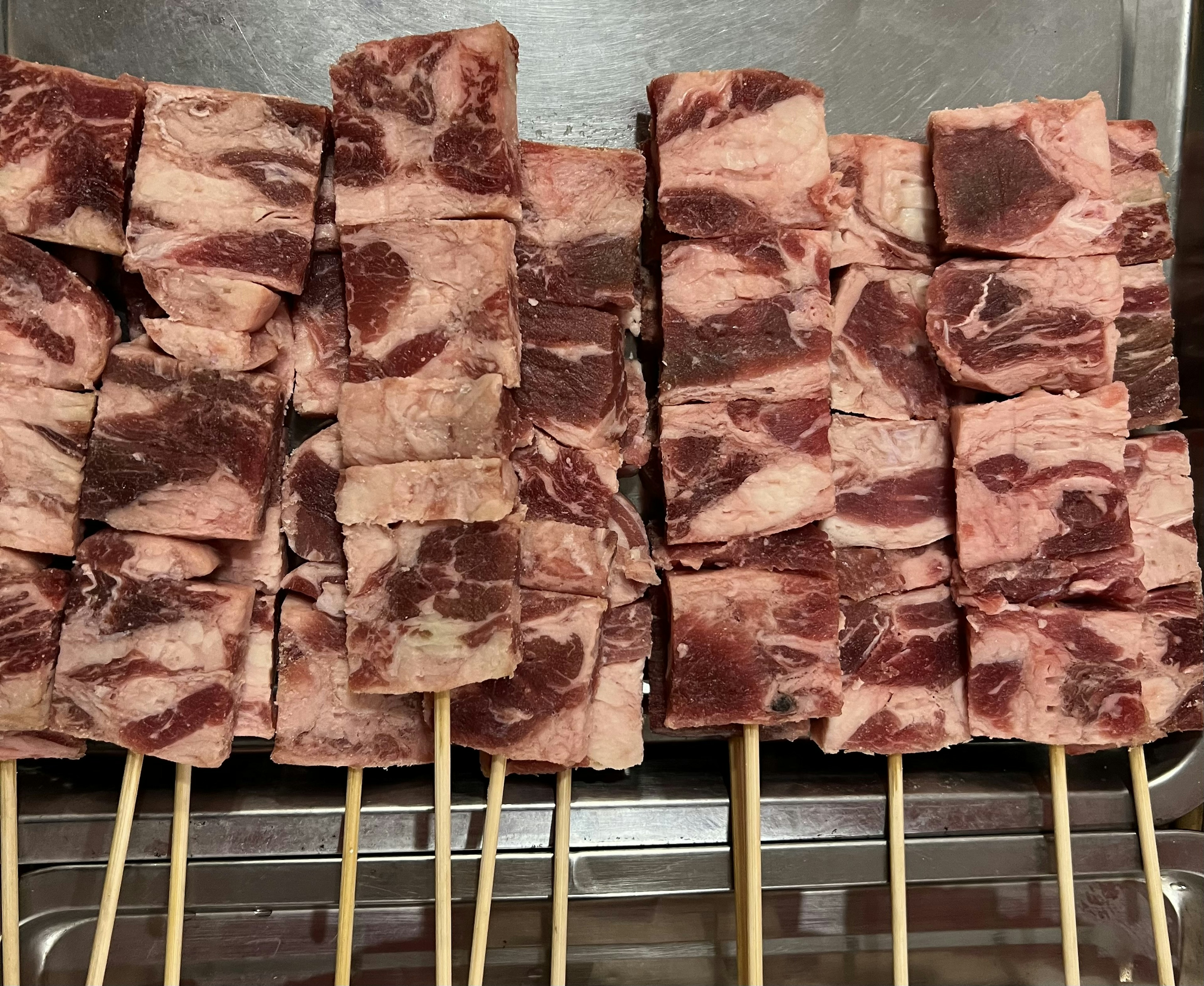 A display of skewered meat pieces arranged neatly