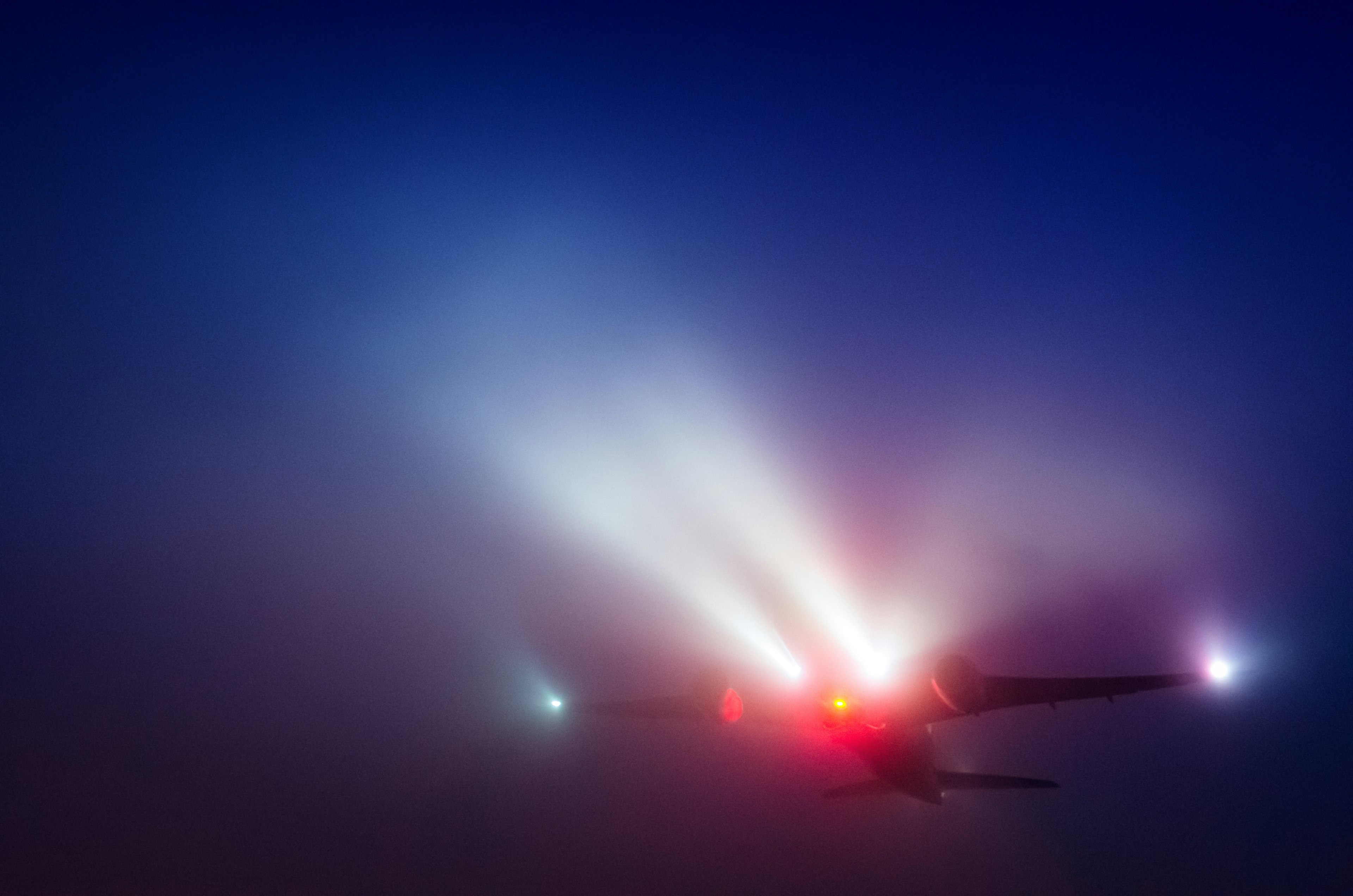 Airplane emitting lights in foggy conditions