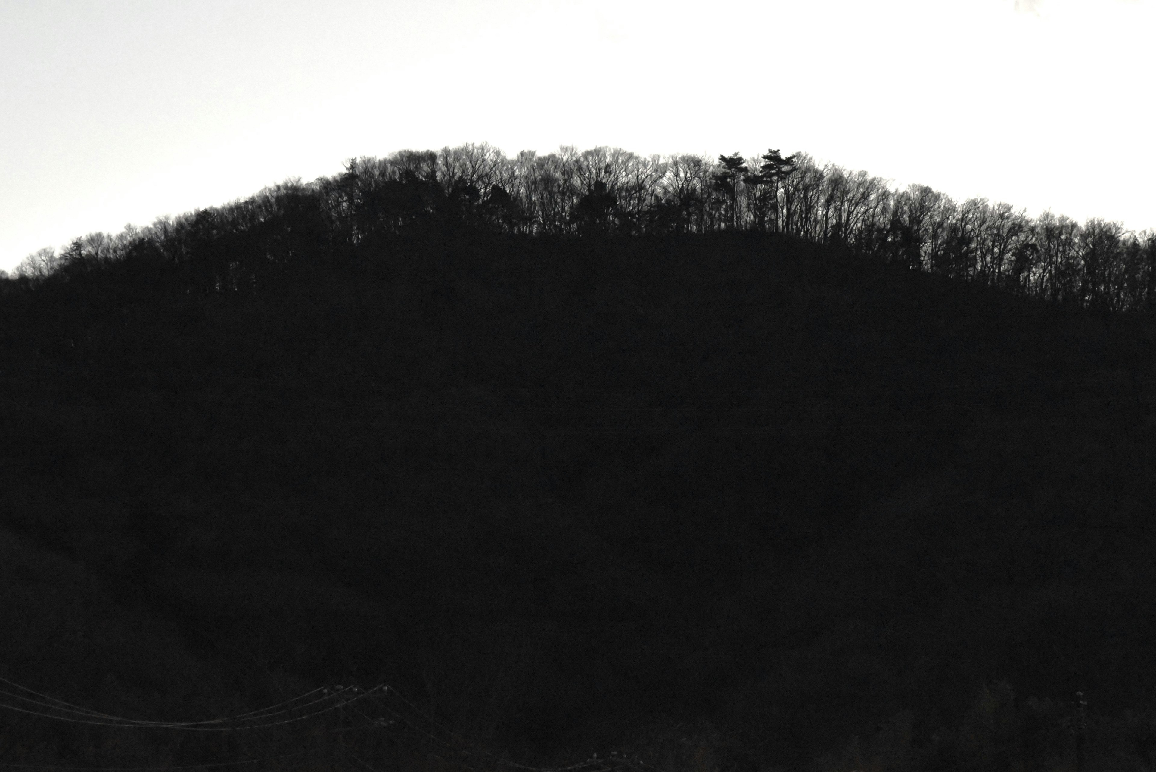 Silhouette of a black mountain against the twilight