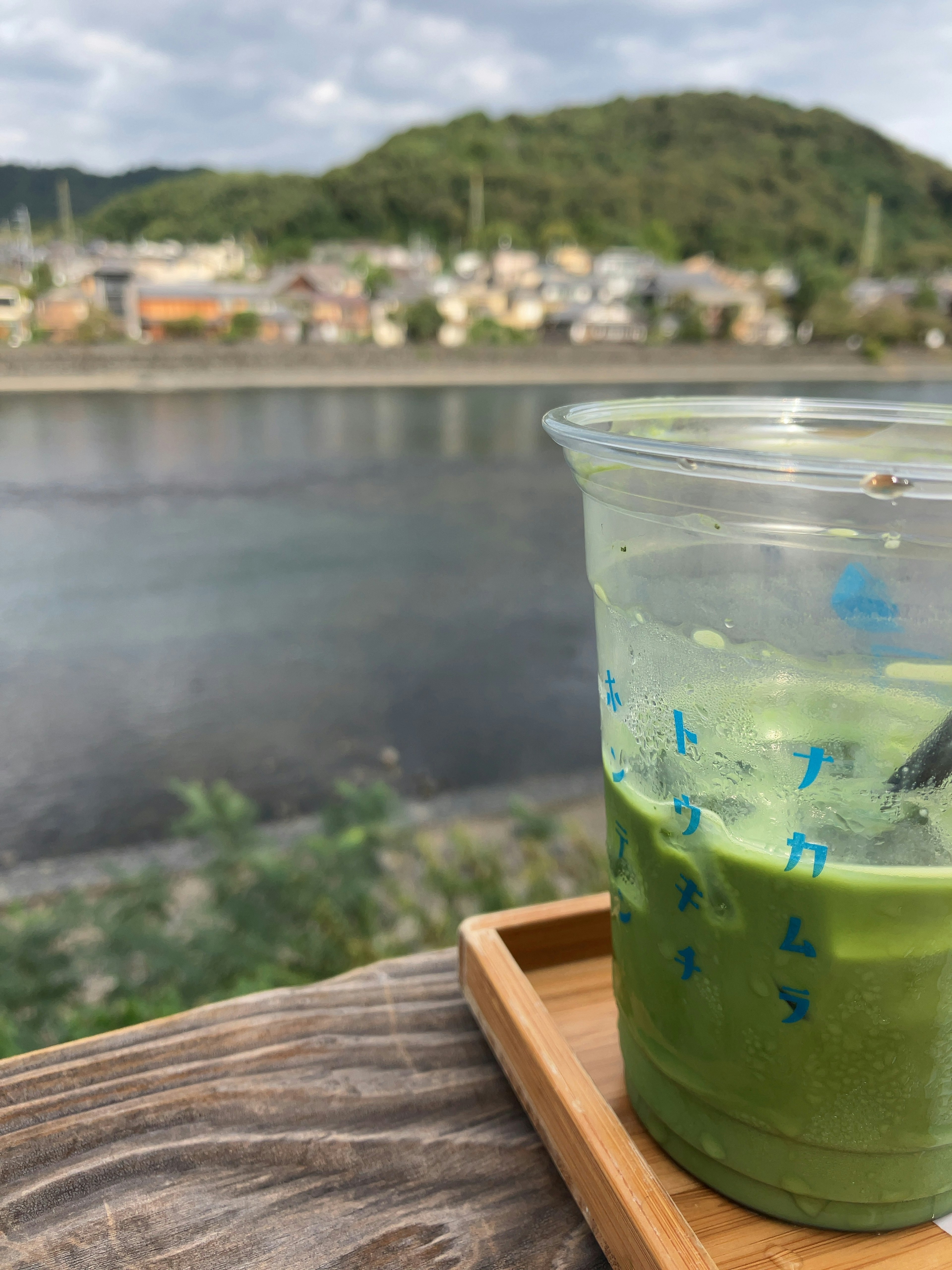 川の景色を背景にした緑茶の飲み物