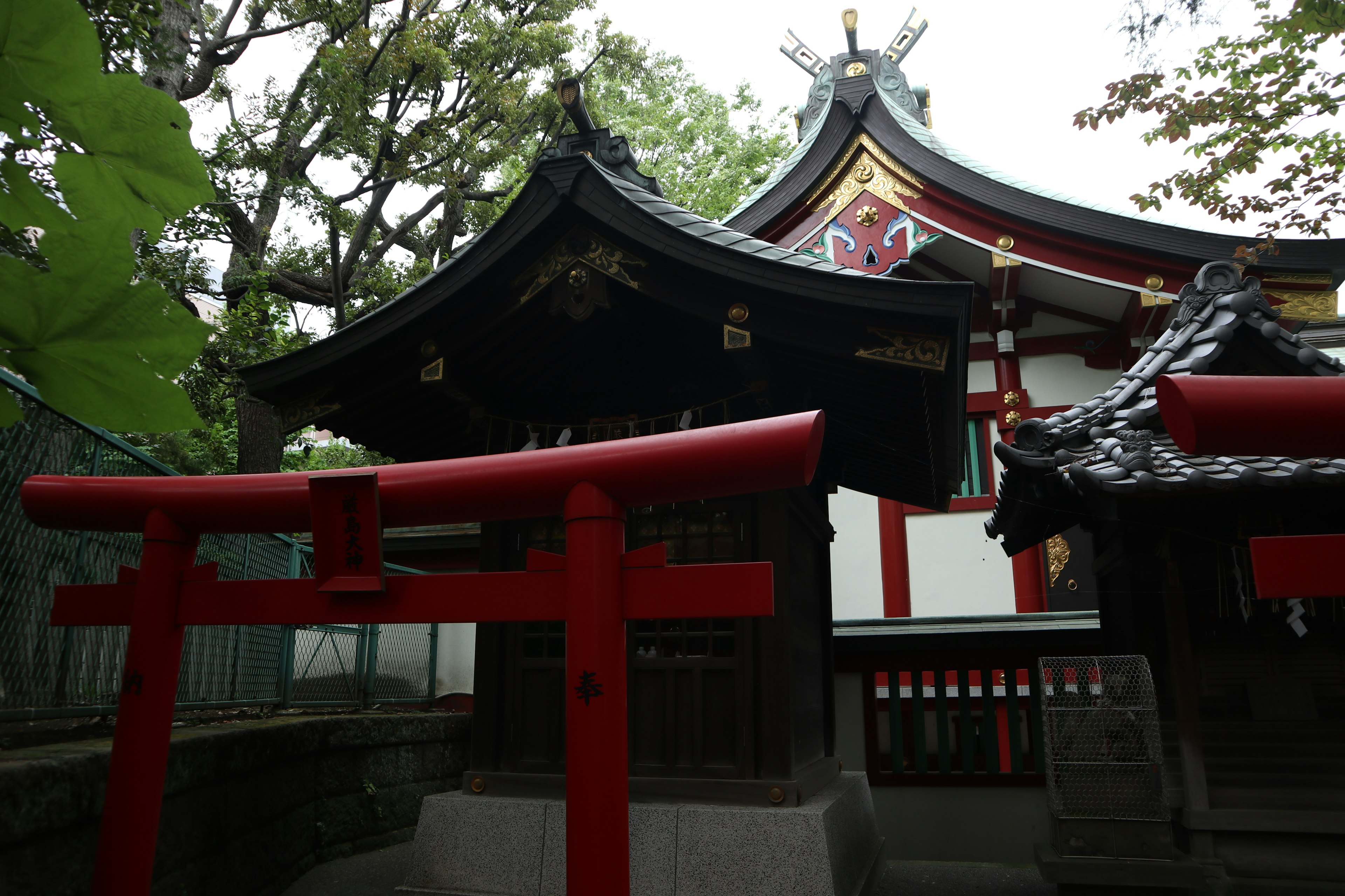 Bâtiment de sanctuaire japonais avec porte torii rouge et toit traditionnel