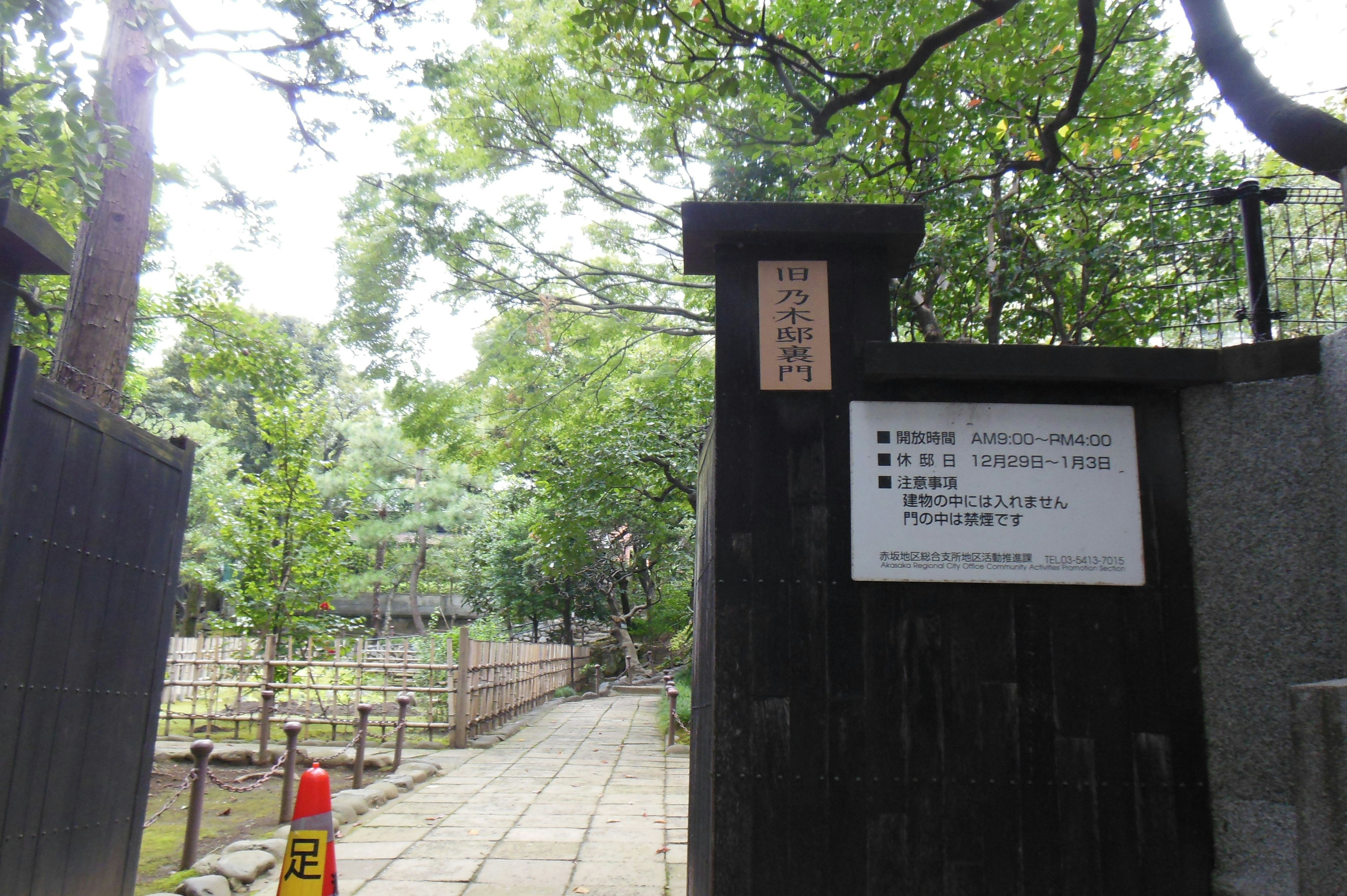 Entrance gate surrounded by greenery with a signboard