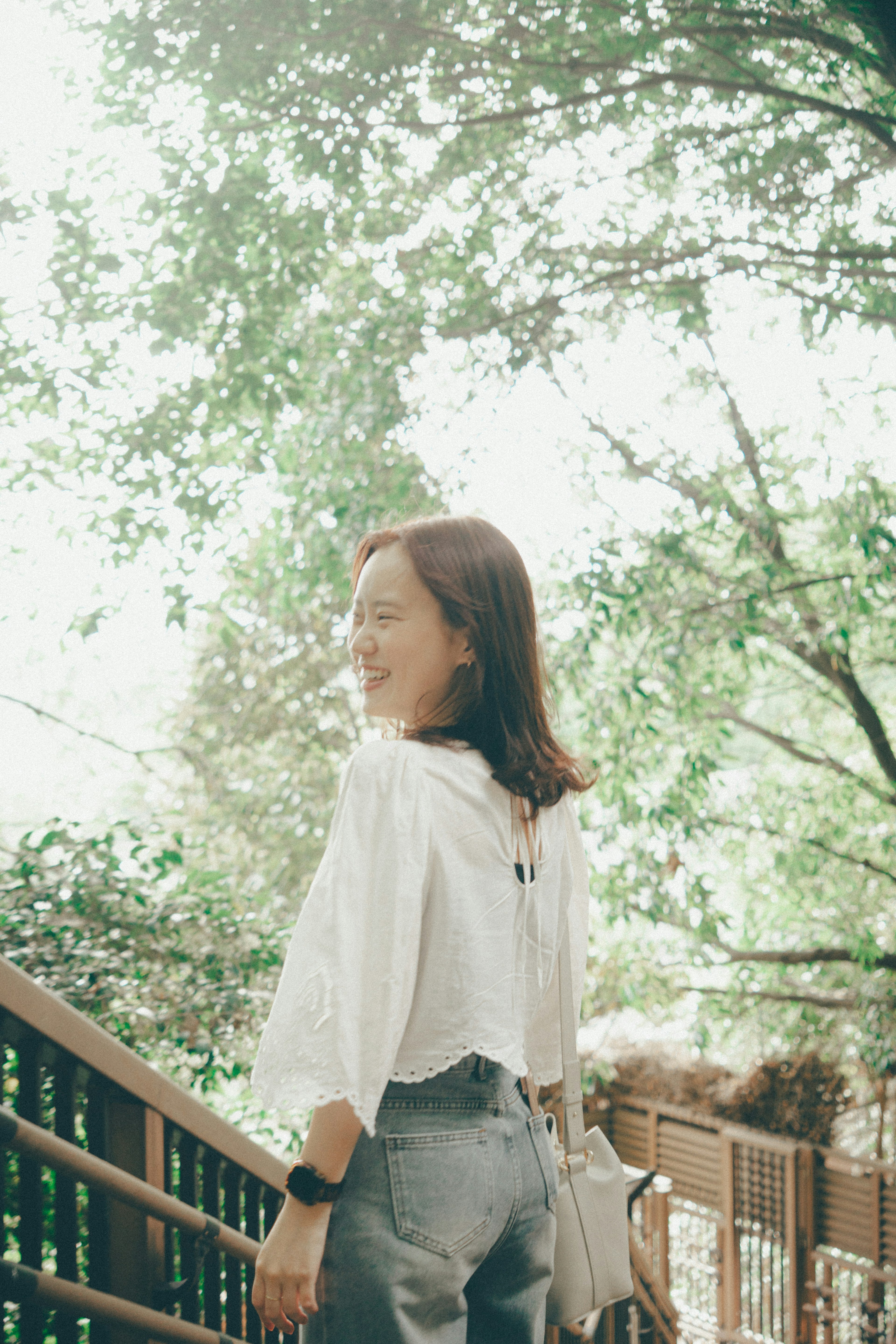 A woman walking on a wooden path surrounded by greenery